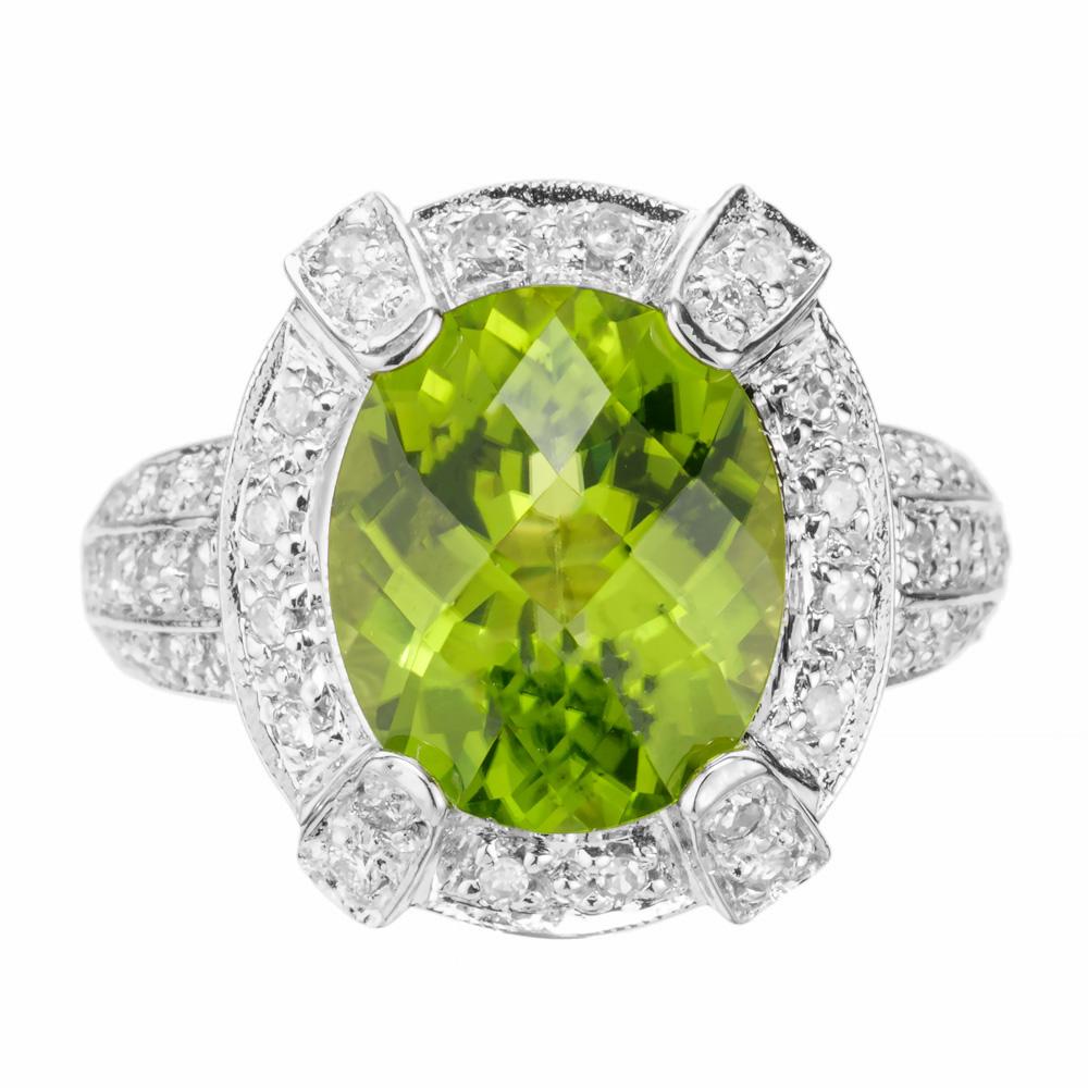 Beautiful bright oval Peridot and diamond ring. 4.20ct faceted top oval center stone in a 14k white gold cocktail setting, with a halo of single cut diamonds accented with three rows of diamonds along both sides of the shank.  

1 oval green