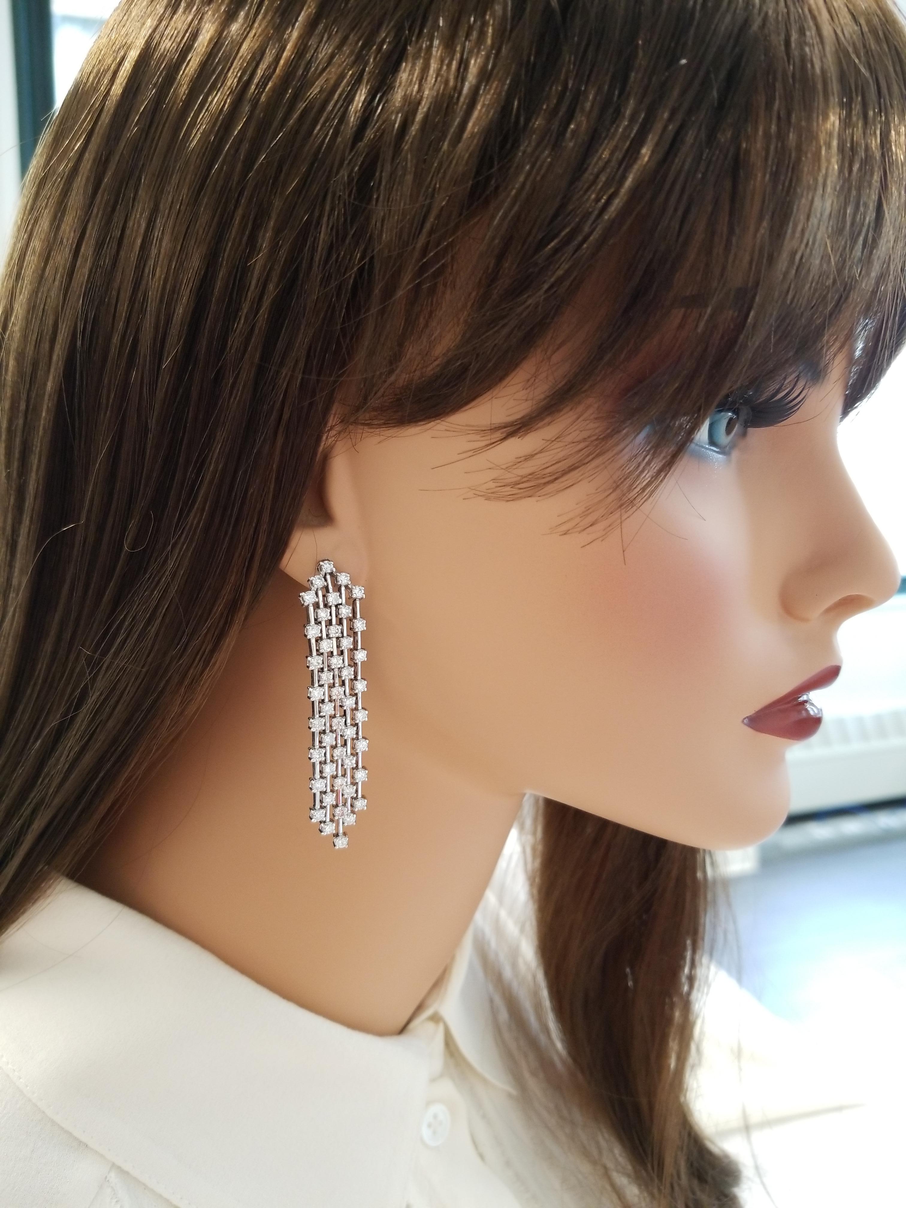 Swinging fringes of 88 round diamonds, prong set, adorn these dramatic dangling earrings with a total weight of 4.20 carats. Designed in brightly polished 14 K white gold, these stunning earrings are made with semi-stiff linear links that resemble a