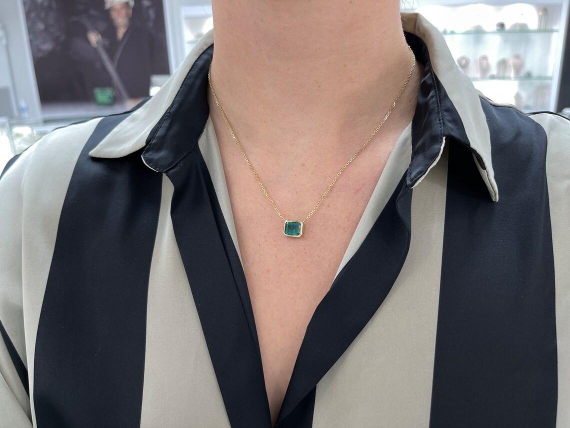 Adorna il tuo décolleté con l'epitome dell'eleganza: una collana di smeraldi solitari. Incastonato orizzontalmente in un castone sicuro, il taglio smeraldo affascina con la sua ipnotica tonalità verde intenso, completata da una sottile sfumatura