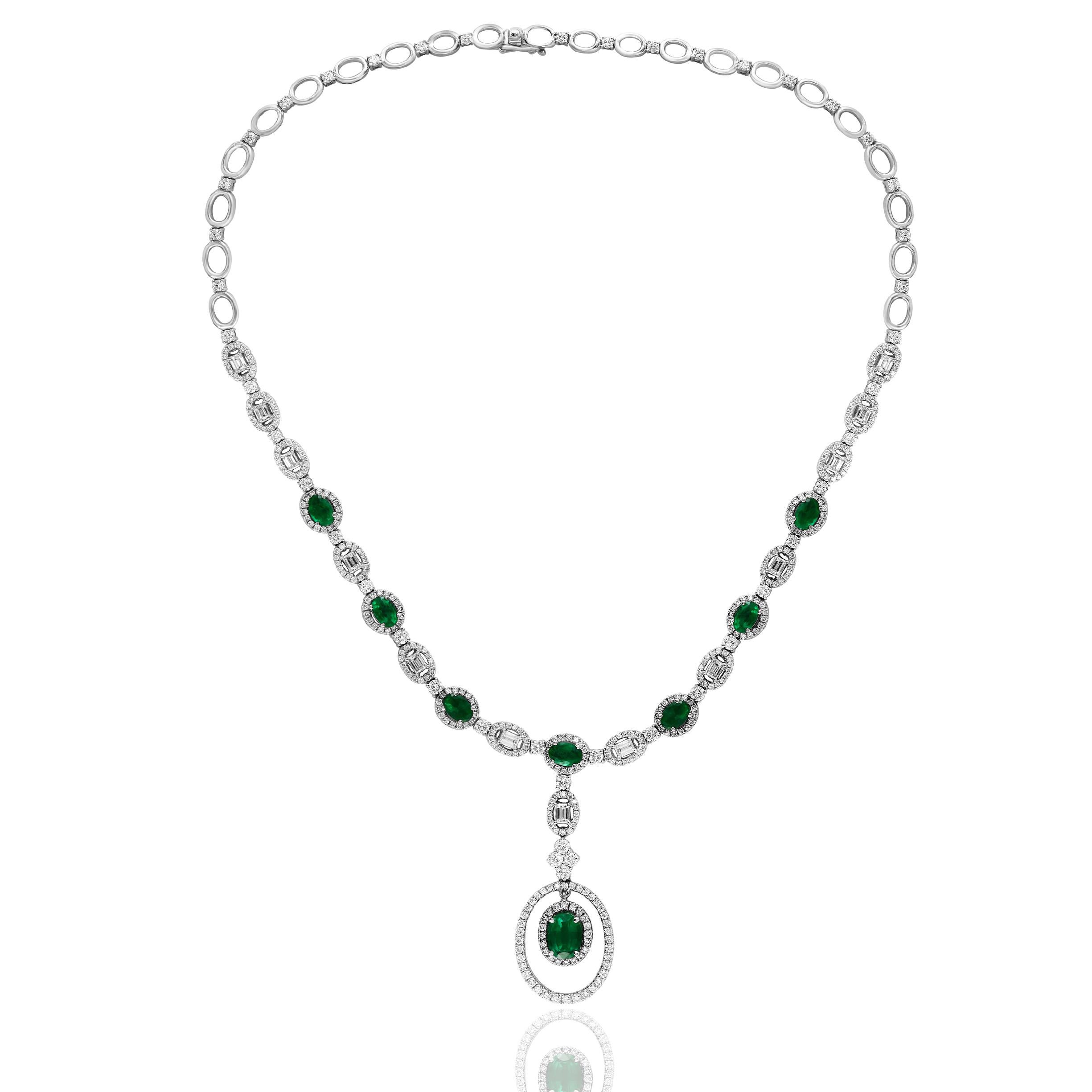 A unique and chic necklace showcasing a drop pendant in an open work design. 8 oval cut emeralds weigh 4.21 carats, and 425 accent diamonds surrounding the emerald weigh approx 5.05 carats. 13 emerald cut diamonds weigh 1.72 carats. Made in 18-karat
