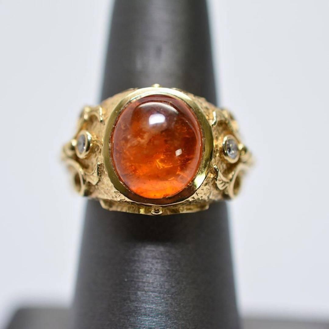 4.21 Carat Spessartite Garnet Cabochon Set in 14K Yellow Gold Ring
14 k yellow gold Spessartite Garnet 4.21 cts. total ring weight 16.4 grams. There are two small Diamond accents.

Ring will be sized free of charge, please state size when