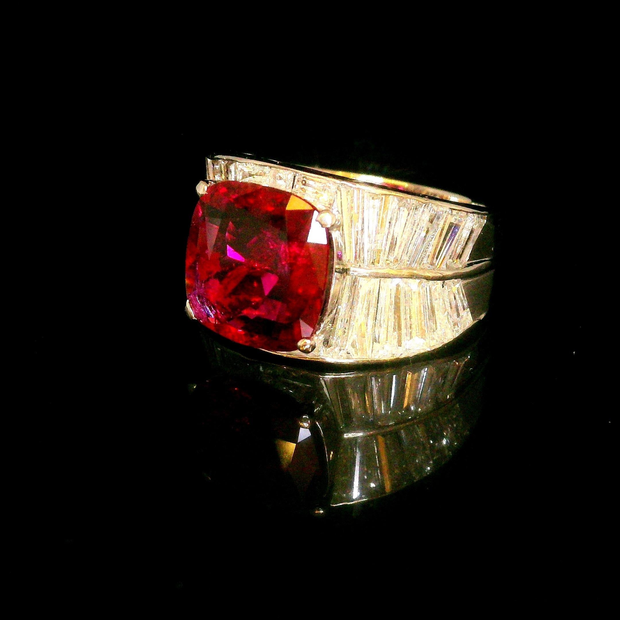 A captivating ruby, weighing 4.21 carats, is the focal point of this contemporary ring. The antique cushion-cut stone radiates a deep red hue. It is flanked by tapered baguette-cut white diamonds, totaling 2.3 carats, which add a refined brilliance.