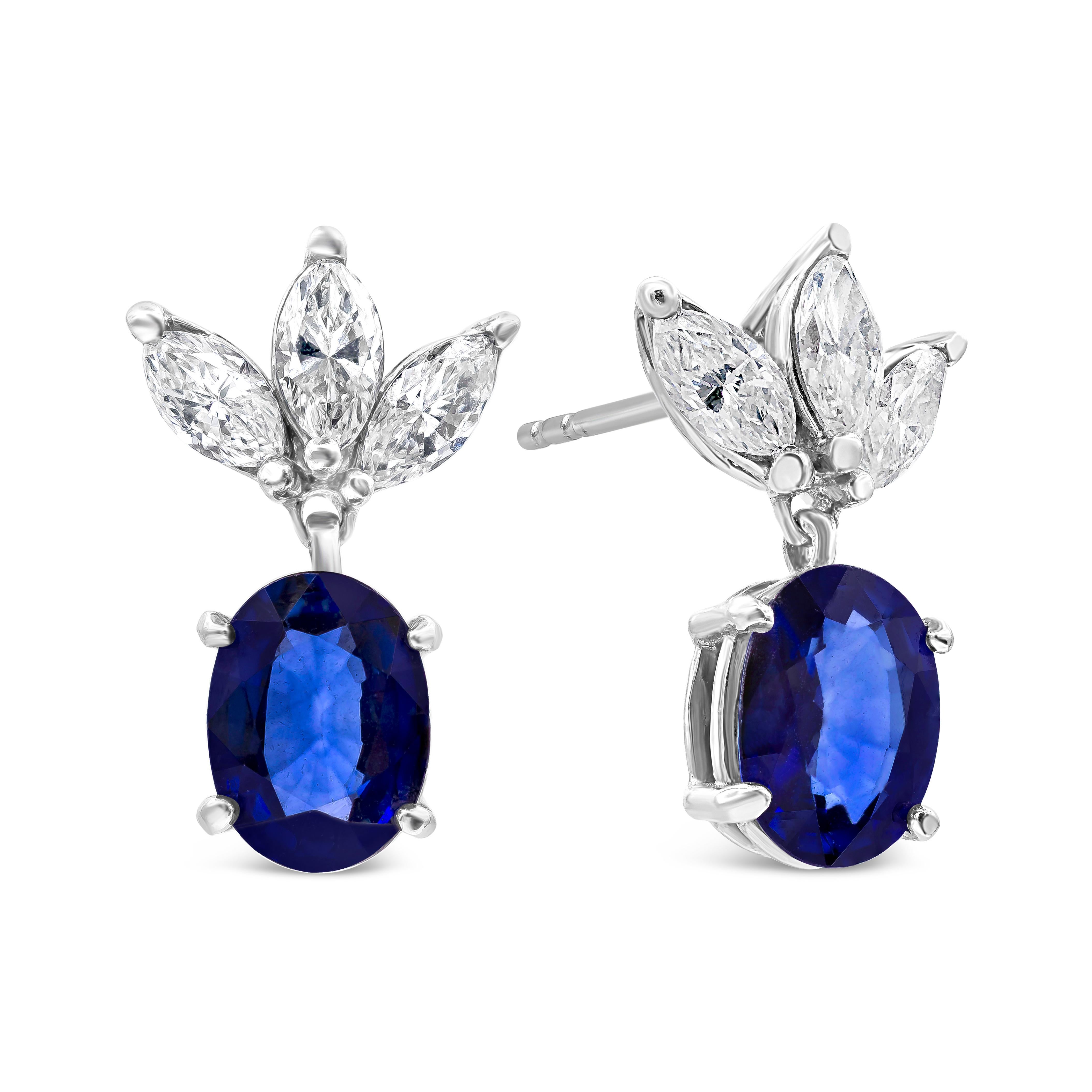Each earring features a color-rich blue sapphire weighing 4.21 carats total, set in a four prong basket setting. Suspended on three marquise cut diamonds weighing 1.21 carats total. Finely made in 14k white gold.
Sapphires are natural corundum but