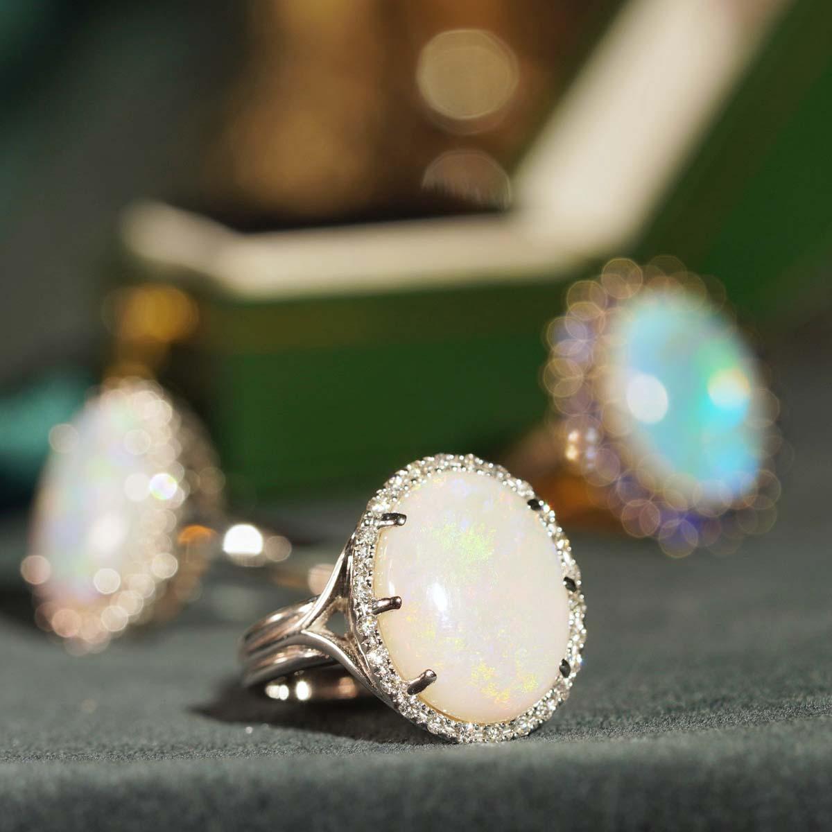 This beautiful ring is a classic vintage inspired style, the halo ring features play-of-color oval 4.22 carat opal for its center, surrounded by twenty-six white diamonds. This would make a wonderful statement ring, or just because it is beautiful.