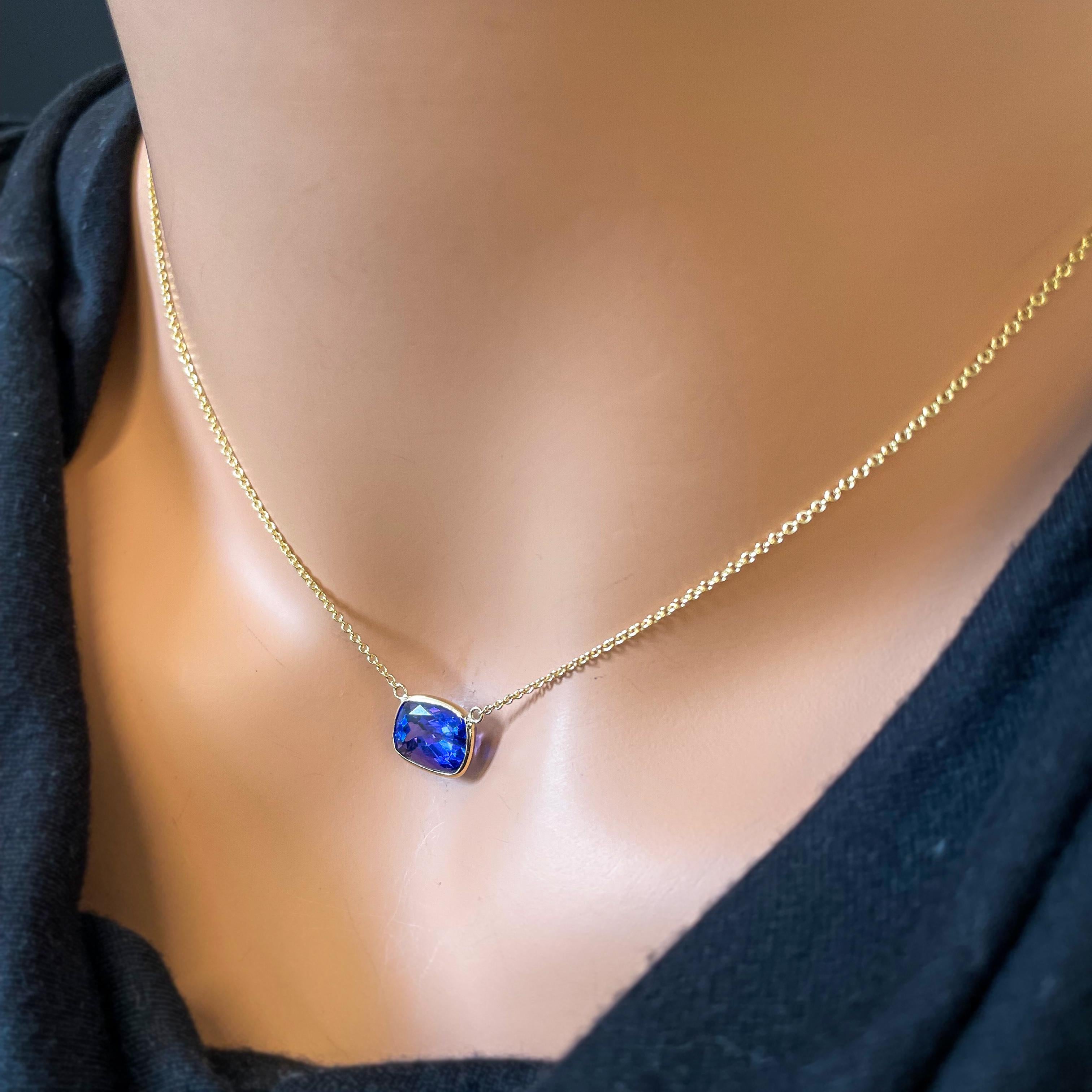 Main stone being a 4.25 carat cushion-cut Tanzanite set in 14k yellow gold (YG). Tanzanite is a beautiful blue-violet gemstone and is known for its striking color and elegance. A cushion cut is a popular choice for gemstones, providing a classic and