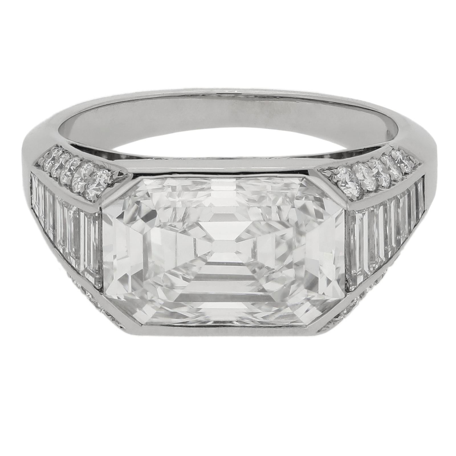 Description
A stunning geometric diamond and platinum ring by Hancocks, centred with a lovely rectangular step cut diamond with canted corners weighing 4.25cts and of G colour and VS1 clarity, set horizontally in a rub over style setting between