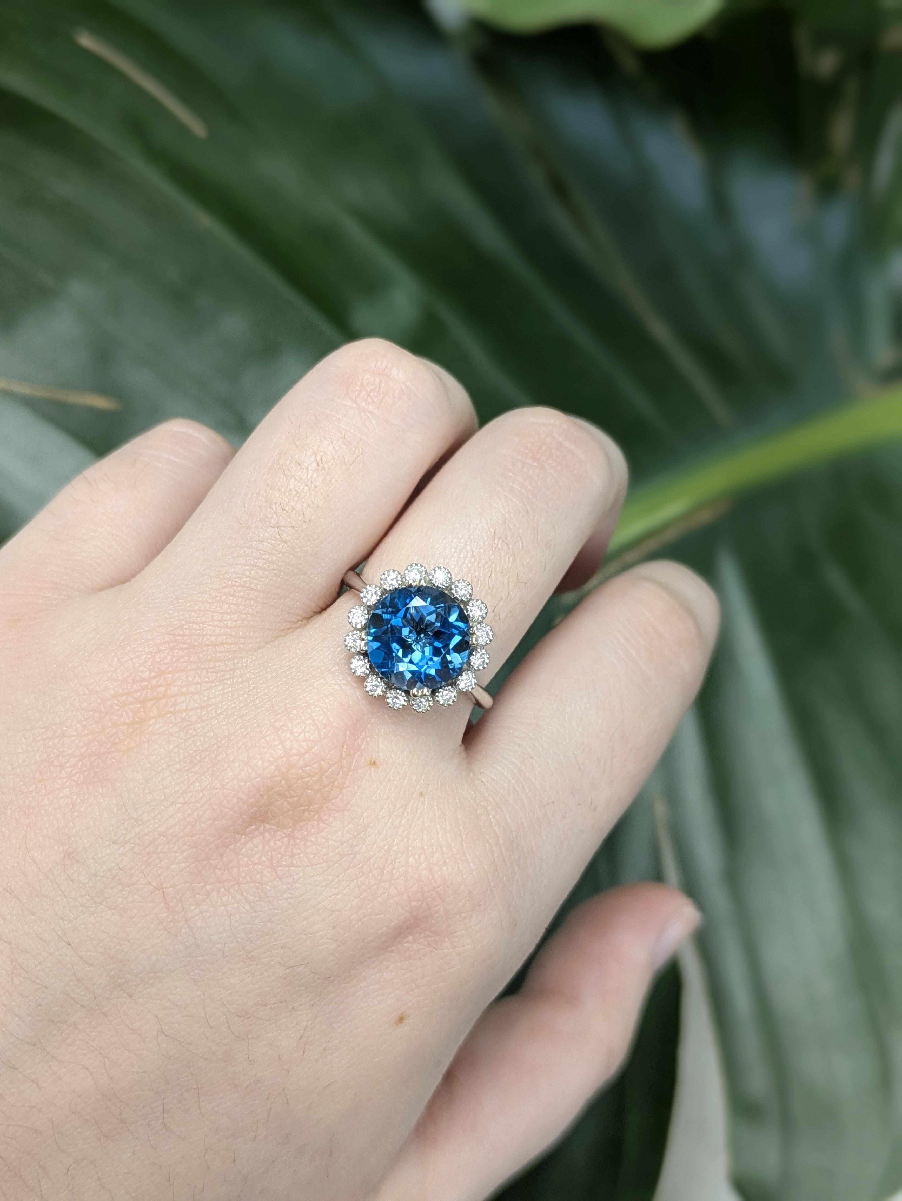Fabriquée en or 14k (3,61 g), cette bague remarquable est ornée d'une topaze bleue de Londres ronde et profonde de 4,25 carats provenant du Brésil et mesurant 10 mm. La teinte bleue riche et sombre est magnifiquement complétée par 16 diamants