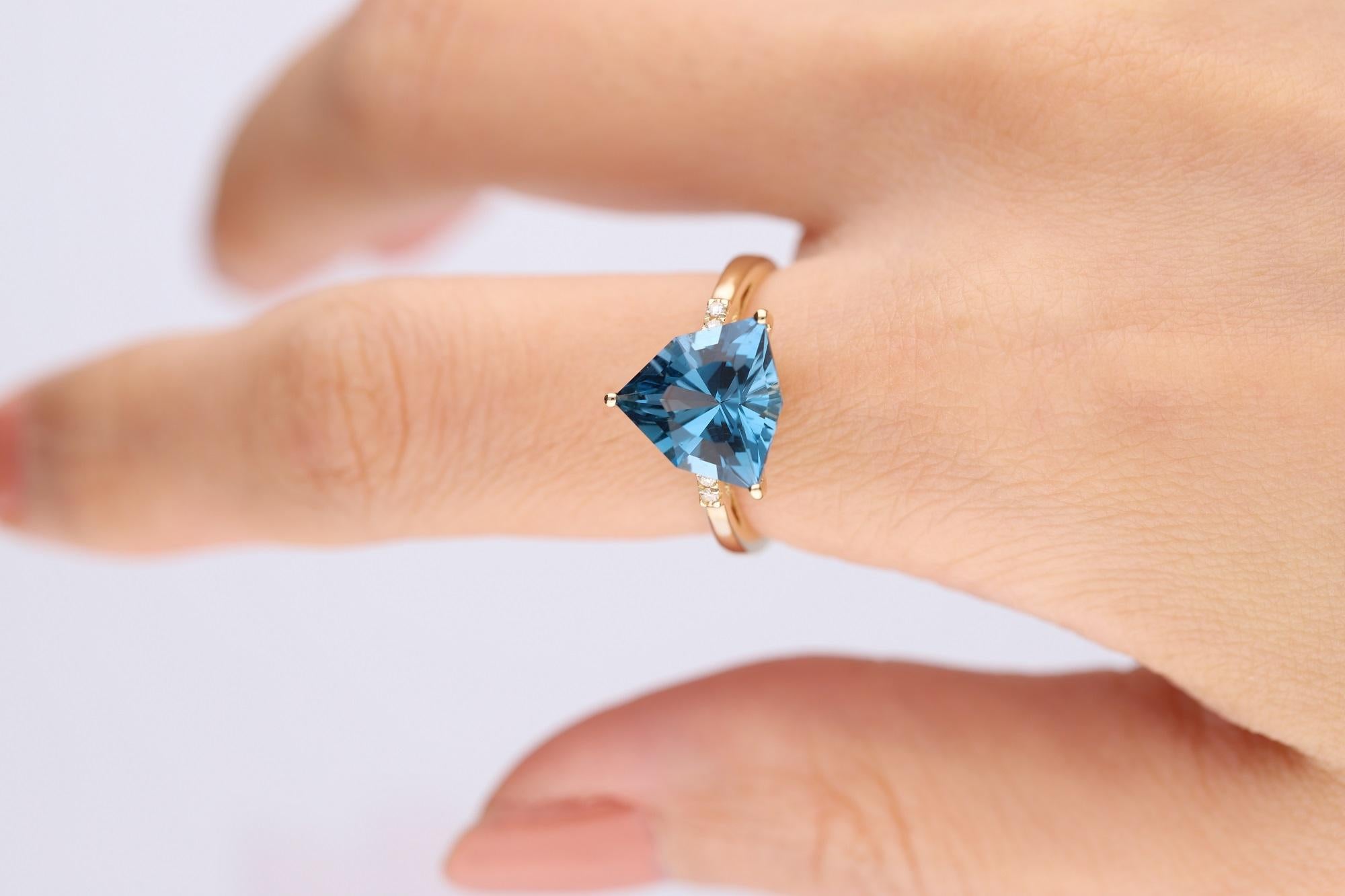 Decorate yourself in elegance with this Ring is crafted from 14-karat Yellow Gold by Gin & Grace. This Ring is made up of Trillion-cut (1pcs) 4.26 carat London Blue Topaz and Round Cut Diamond (4 Pcs) 0.03 Carat . This Ring is weight 2.58 grams.