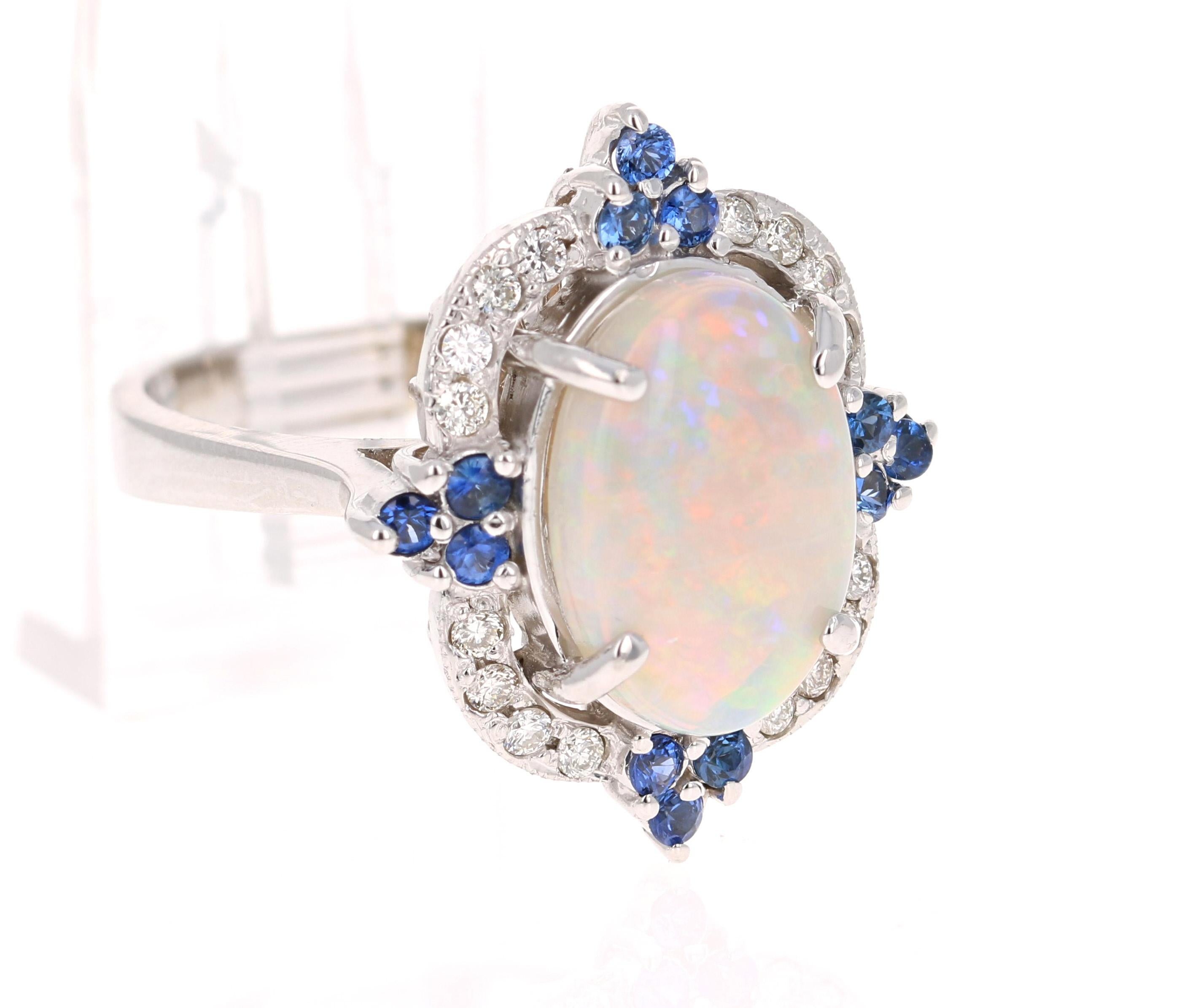 Opulent Opal, Blue Sapphire and Diamond Ring in 14K White Gold.

The beautiful Oval Cut, Ethiopian-Origin Opal with its striking flashes of color weighs 3.57 Carats. The Opal has flashes of color ranging from green, orange, yellow and red.  It is