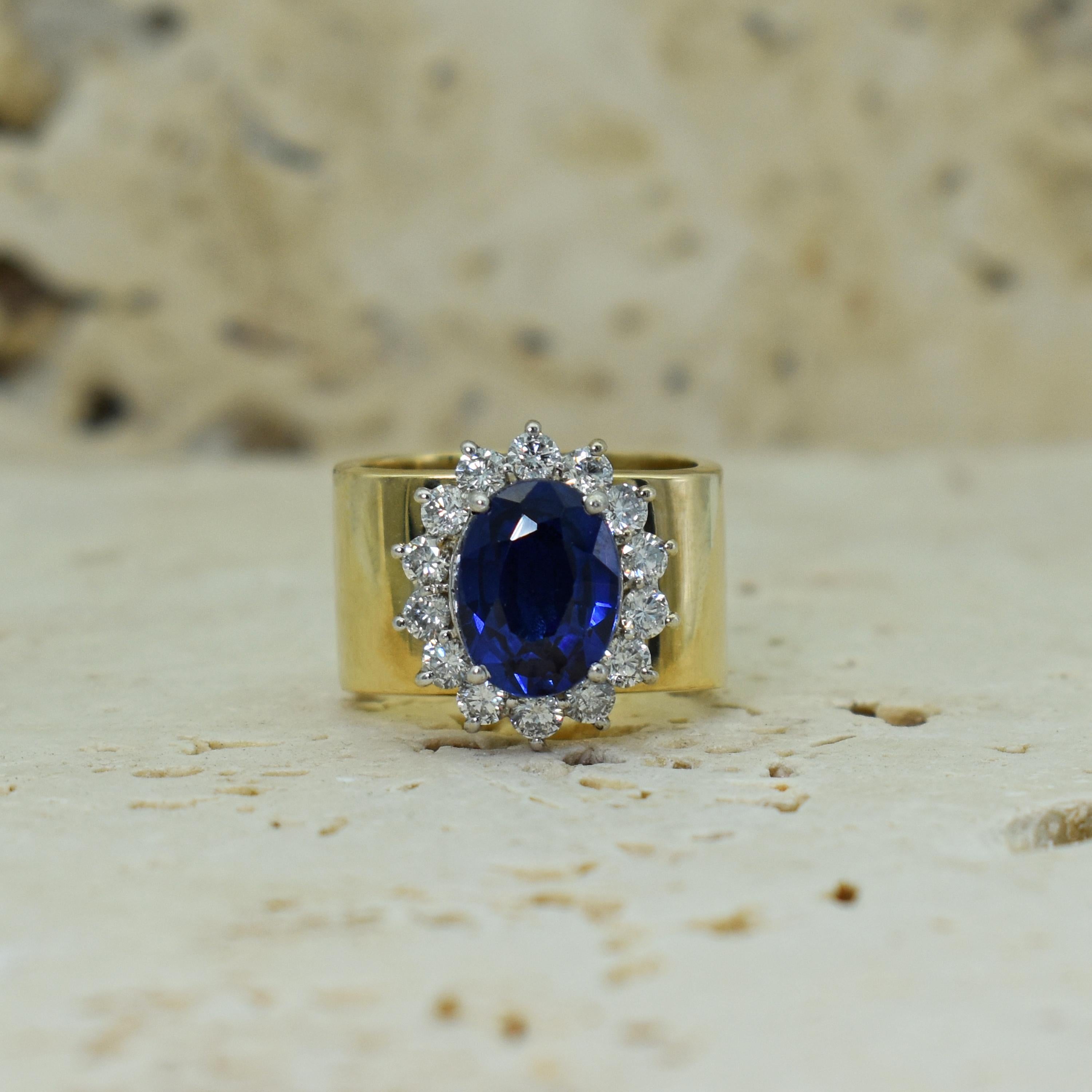 4.27 carat oval blue Sapphire and white Diamond halo (1.05 total carats, SI2-I1 clarity, G-H color) in a 14k white gold setting on a solid 14k yellow gold square ring band. Size 7. Gorgeous Sapphire set in a unique, yet timeless cocktail ring.