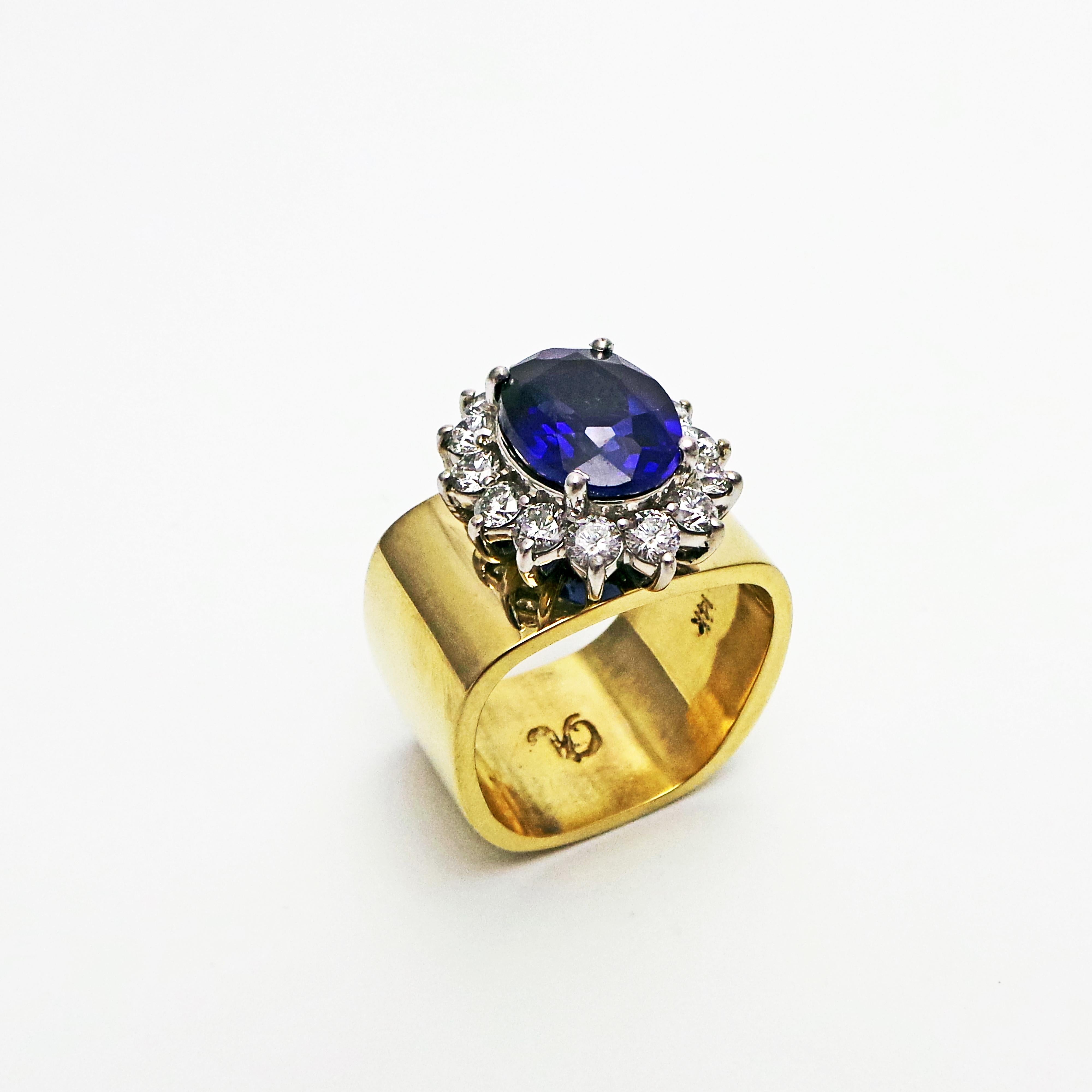 4.27 carat oval Sapphire with Diamond halo (weighing 1.05 carats total, SI2-I1 clarity, G-H color) set in 14k white gold, and mounted onto a solid 14k yellow gold square band. Size 7. Timeless setting with a modern twist.