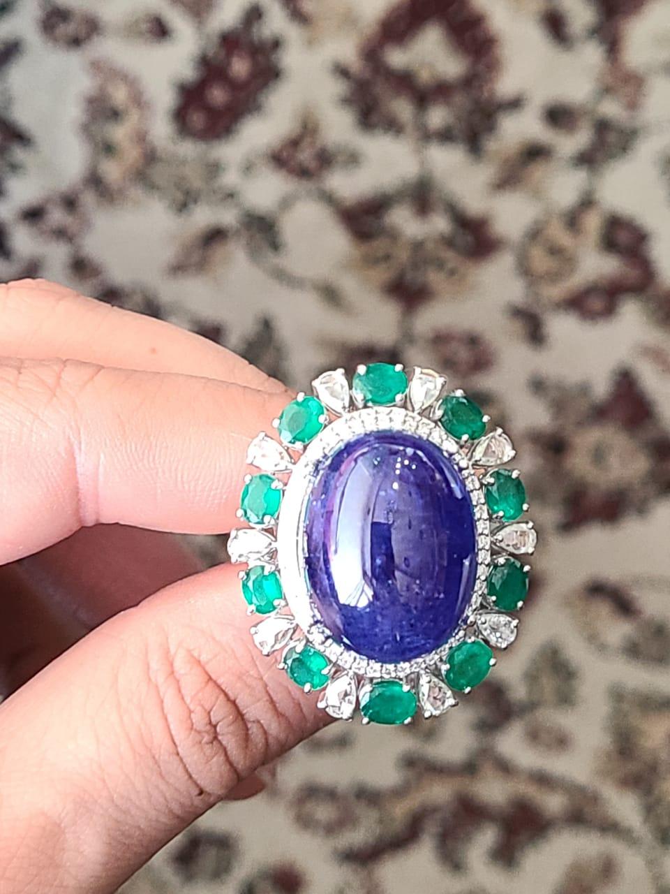 A very beautiful and one of a kind, Tanzanite & Emerald Cocktail/ Dome Ring set in 18K Gold & Diamonds. The weight of the Tanzanite cabochon is 42.70 carats. The Tanzanite is completely natural, without any treatment and is from Tanzania. The weight