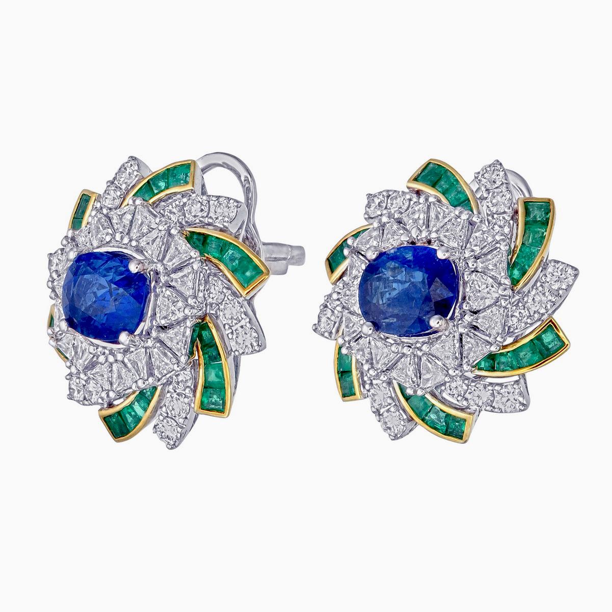 An elegant pair of coloured stones and diamond earrings from Rewa Jewels is made in 18 karat white gold.

The centre is decorated with 2 pieces of natural Blue Sapphire weighing approximately total of 3.07 carats. Surrounded with Emerald old cut 48