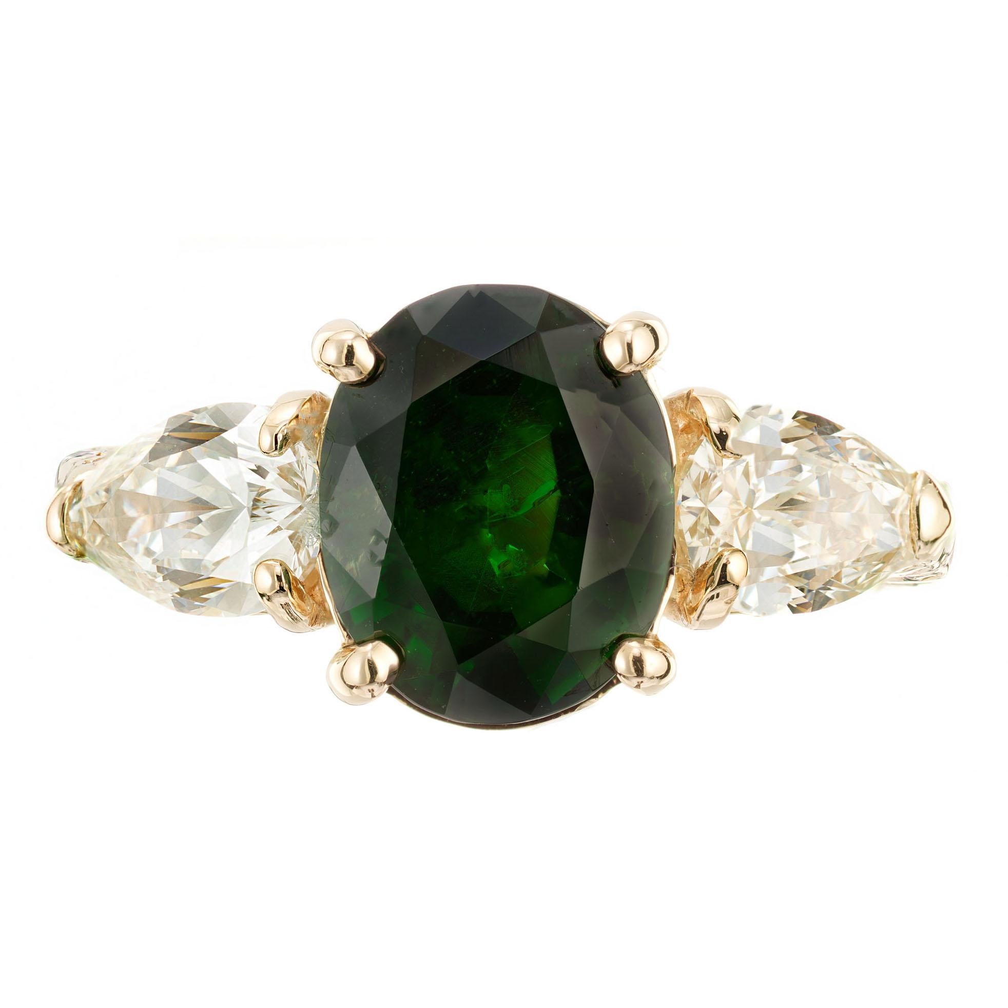 4.28ct Tsavorite Garnet and diamond engagement ring. AGL certified oval Tsavorite center stone with 2 pear shaped side diamonds in a 14k yellow gold open work setting with and engraved shank. Circa 1960-1970

1 oval bright gem green natural