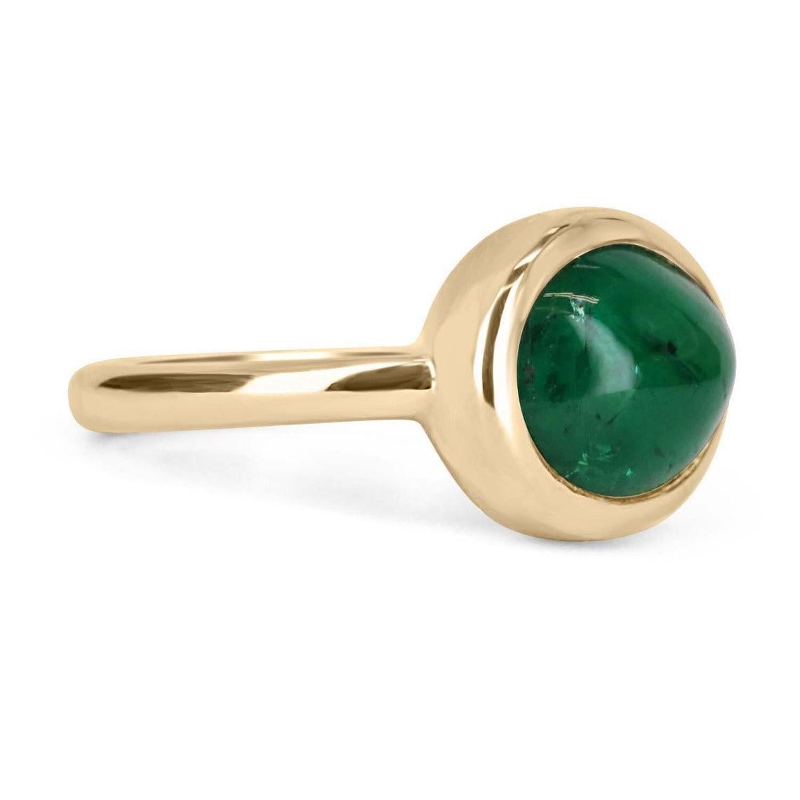 A bezel-set emerald cabochon ring in 14K yellow gold. Featured here is this lovely 4.77-carat natural, earth-mined, emerald cabochon. This stone displays a gorgeous, dark green color, and very good luster. This natural beauty is set in a 14K yellow