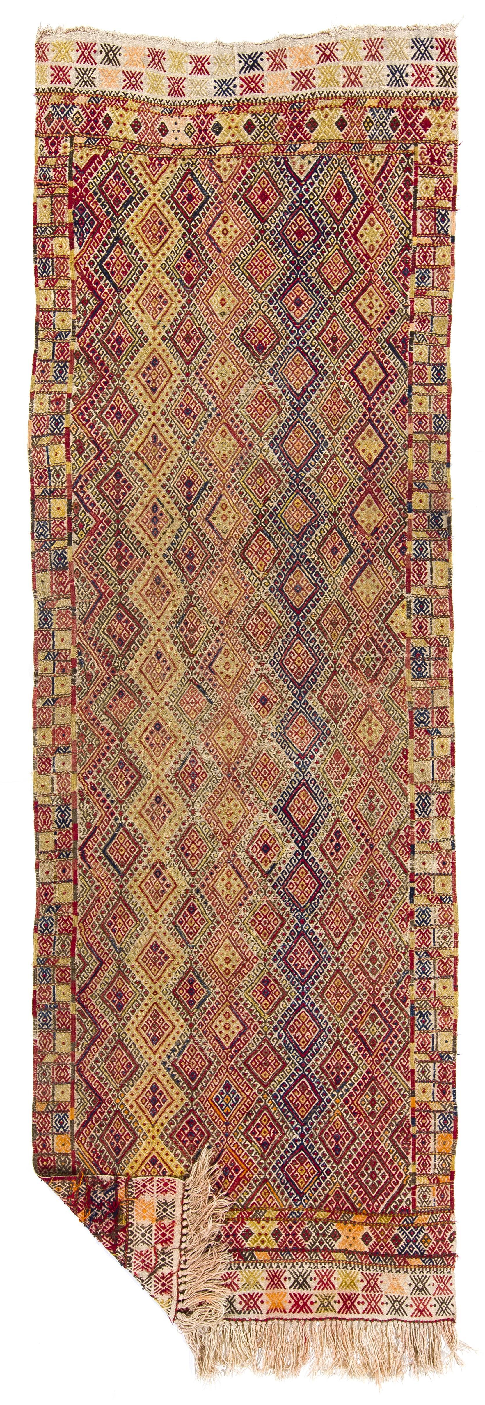 This attractive flat-weave runner rug is handwoven in fine local wool to create a sturdy floor covering featuring an all-over burdock design in soft, warm shades of dark and light moss green, terra cotta red and navy blue. 

Kilims of this type,