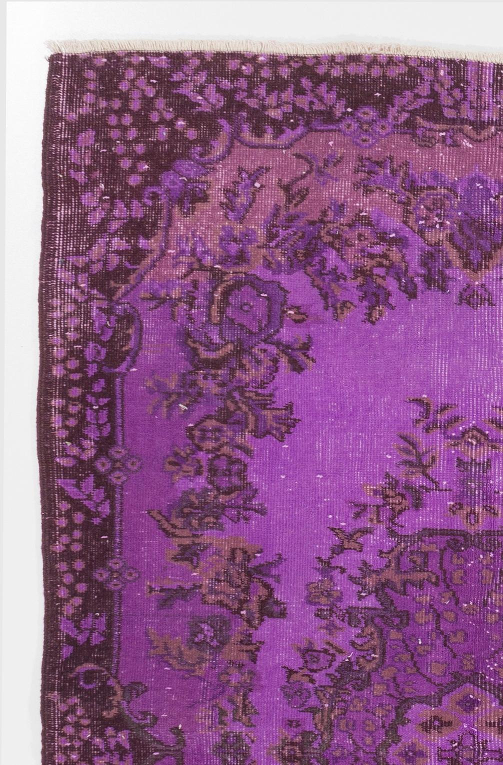 A vintage Turkish accent rug with a medallion at its centre, surrounded by a large, lush floral wreath, over-dyed in purple. It is finely hand-knotted with low wool pile on cotton foundation, in good condition, professionally washed, sturdy and
