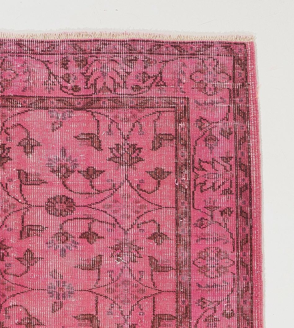 A vintage handmade Turkish area rug with low wool pile on cotton foundation, over-dyed in pink, featuring an all-over, symmetrical floral design.
In very good condition. Professionally washed. Sturdy and suitable for use on a high traffic area in