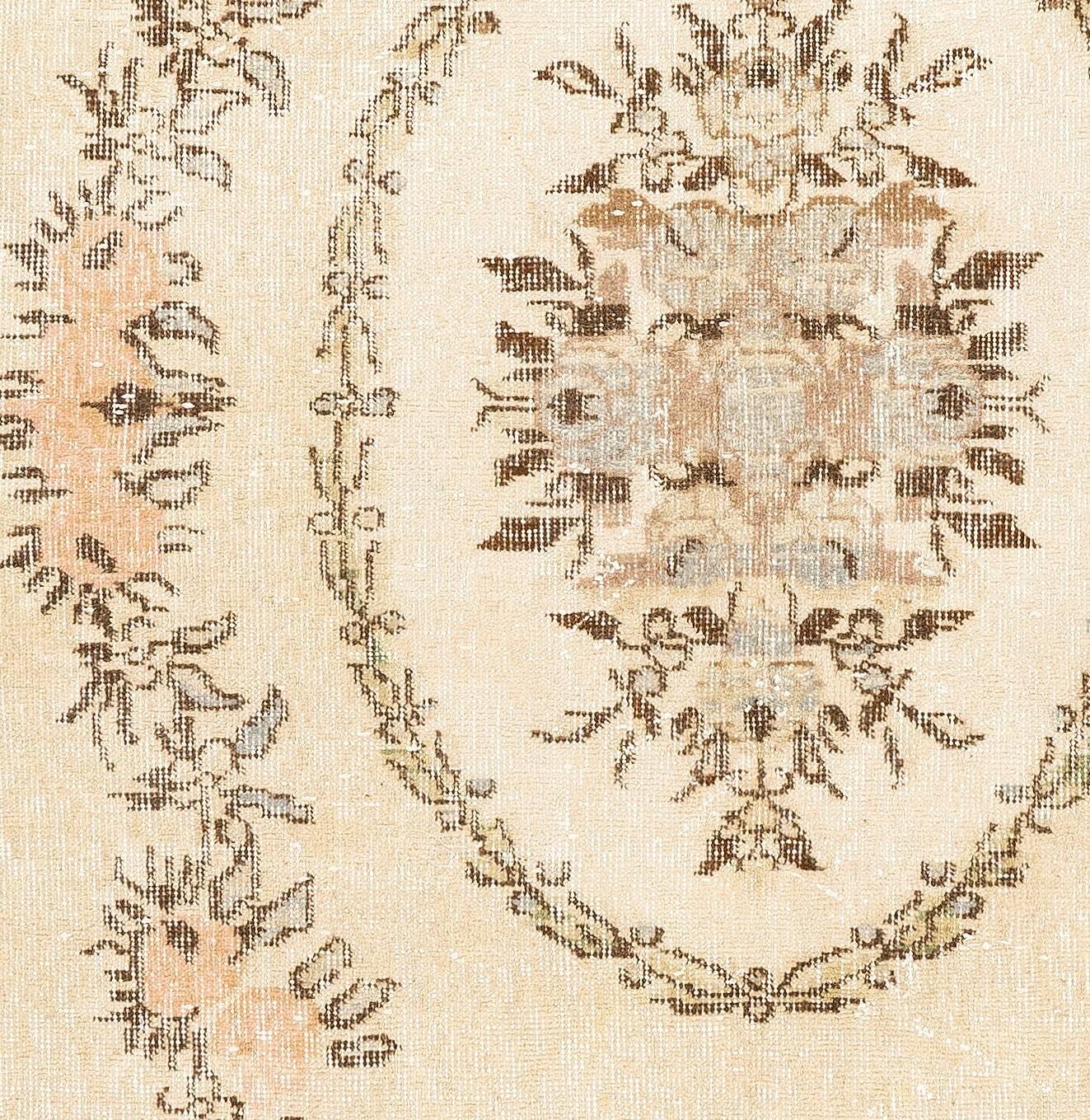 A finely hand-knotted vintage Turkish rug from the 1960s featuring a French-Aubusson inspired floral wreath design in soft peach, light blue, taupe gray and brown against a warm beige background. Size: 4.2 x 7.2 Ft.

The rug has even low wool pile