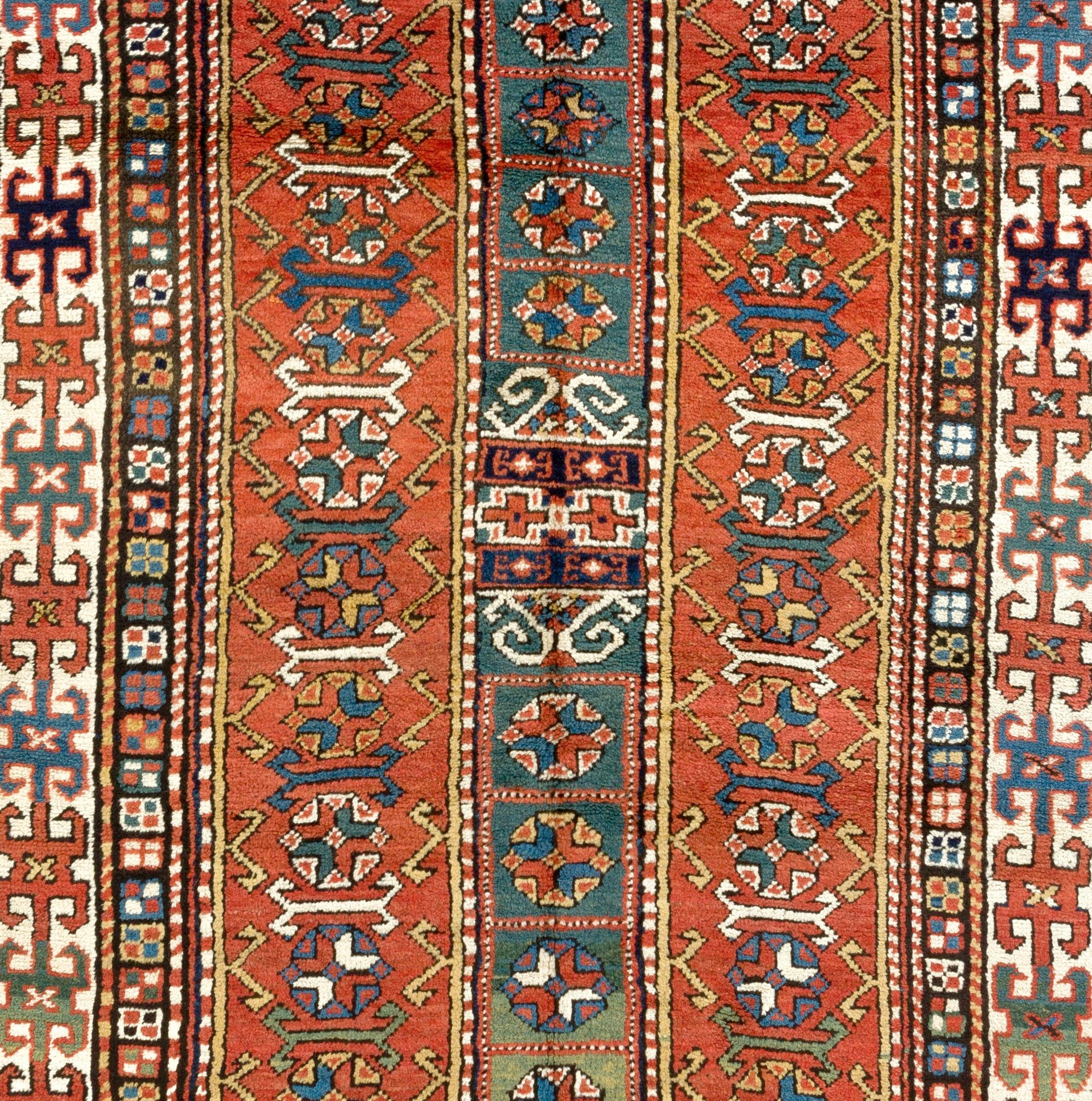 A highly decorative antique West Caucasian Kurdish rug in good condition with soft even medium pile from late 19th century with great visual interest. The rug features two narrow elongated lozenge-shaped red panels with another narrow rectangular