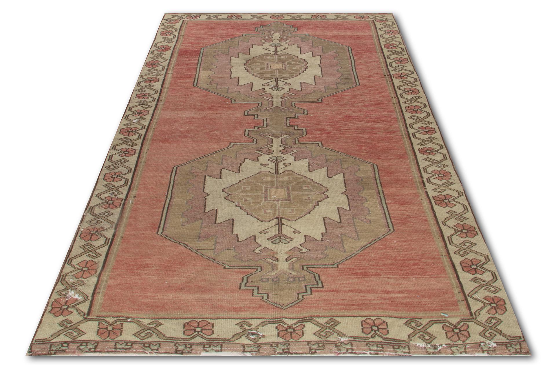 A vintage Turkish rug with medium to low wool pile, hand-knotted in the 1960s with a design of linked double medallions against a plain field in faded red and a floral border.

The rug is in good condition, sturdy and clean as a brand new rug. It