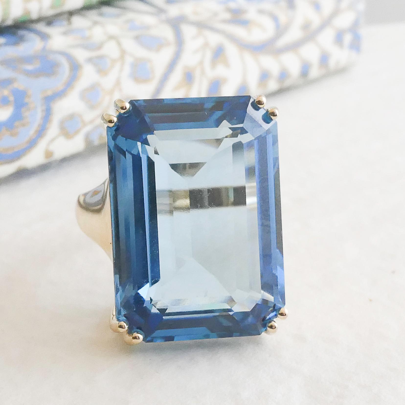 Elevate your style with this breathtaking 43-carat London Blue Topaz ring, crafted to perfection. The stunning emerald-cut gemstone, measuring 17x24mm, displays a deep and captivating blue hue with remarkable brilliance. Set in a luxurious 14K