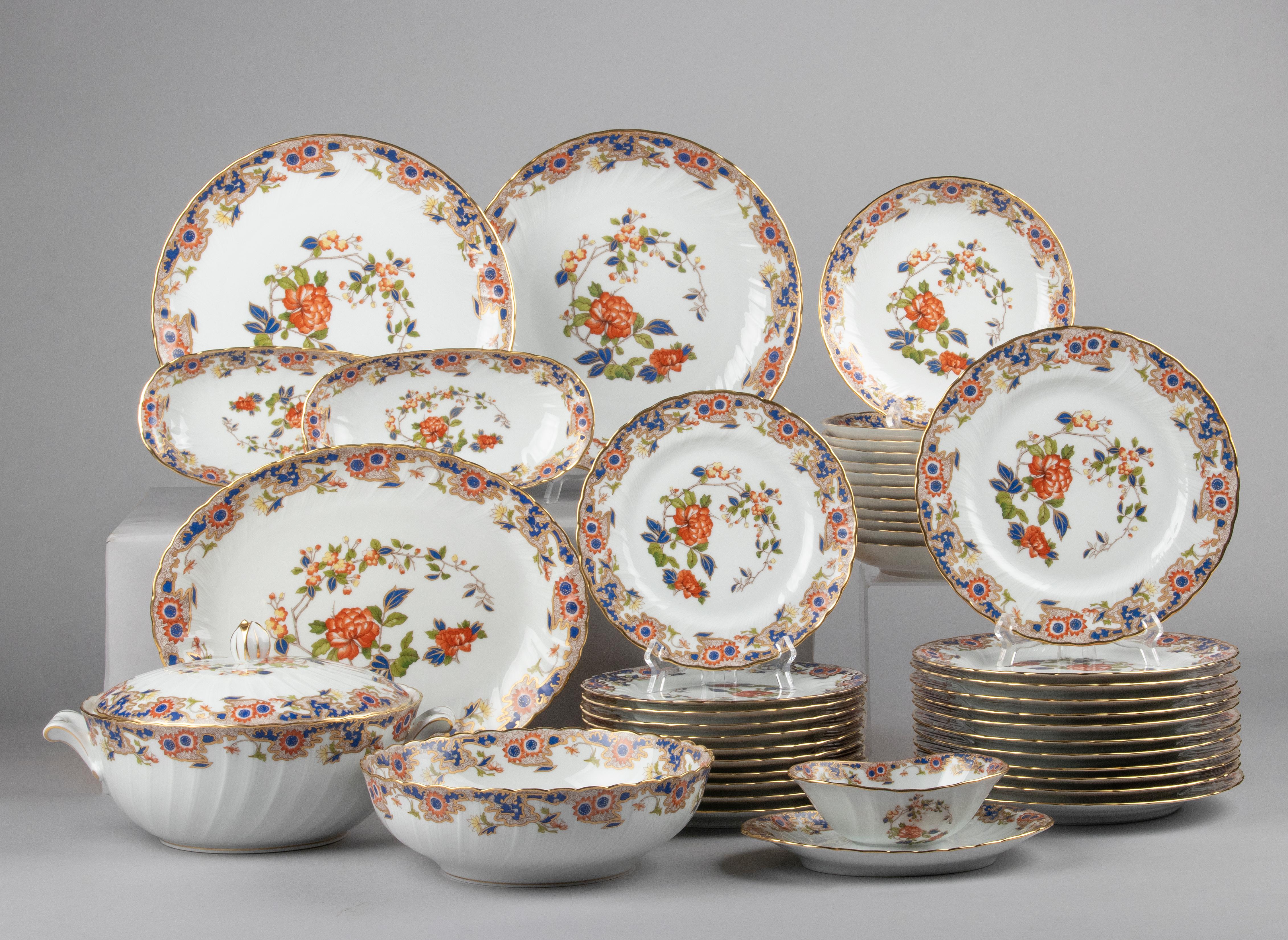 Lovely set of porcelain dinnerware made by Bernardaud Limoges. The name of the pattern is Singapour. This model was issued by Bernardaud from 1986 until 1998. The plates are very decorative with colorful flowers and gold rims. The quality of the