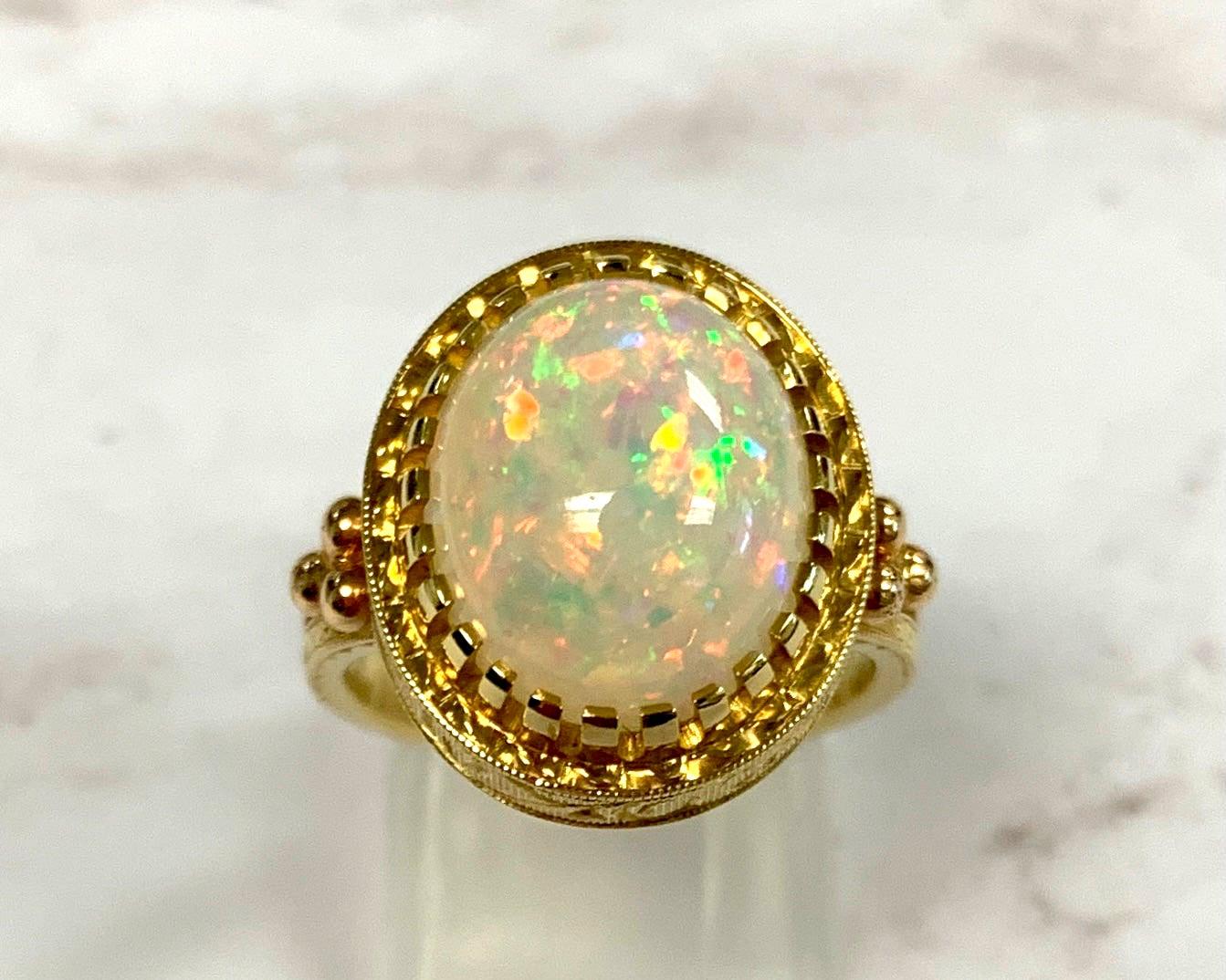 The 4.30 carat opal in this handmade 18k yellow gold ring is bursting with color! This gemstone displays flashes of bright green, orange, yellow, and the most highly-prized and rare color: red! It is difficult for photos to do this opal justice.