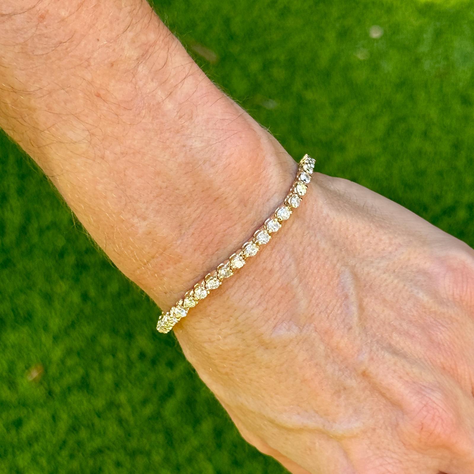 Diamond tennis bracelet crafted in 14 karat yellow gold. The bracelet features 44 round brilliant cut diamonds weighing approximately 4.30 CTW and grade I color and SI2-I1 clarity. The bracelet measures 7.0 inches in length and 3.5mm in width. Box