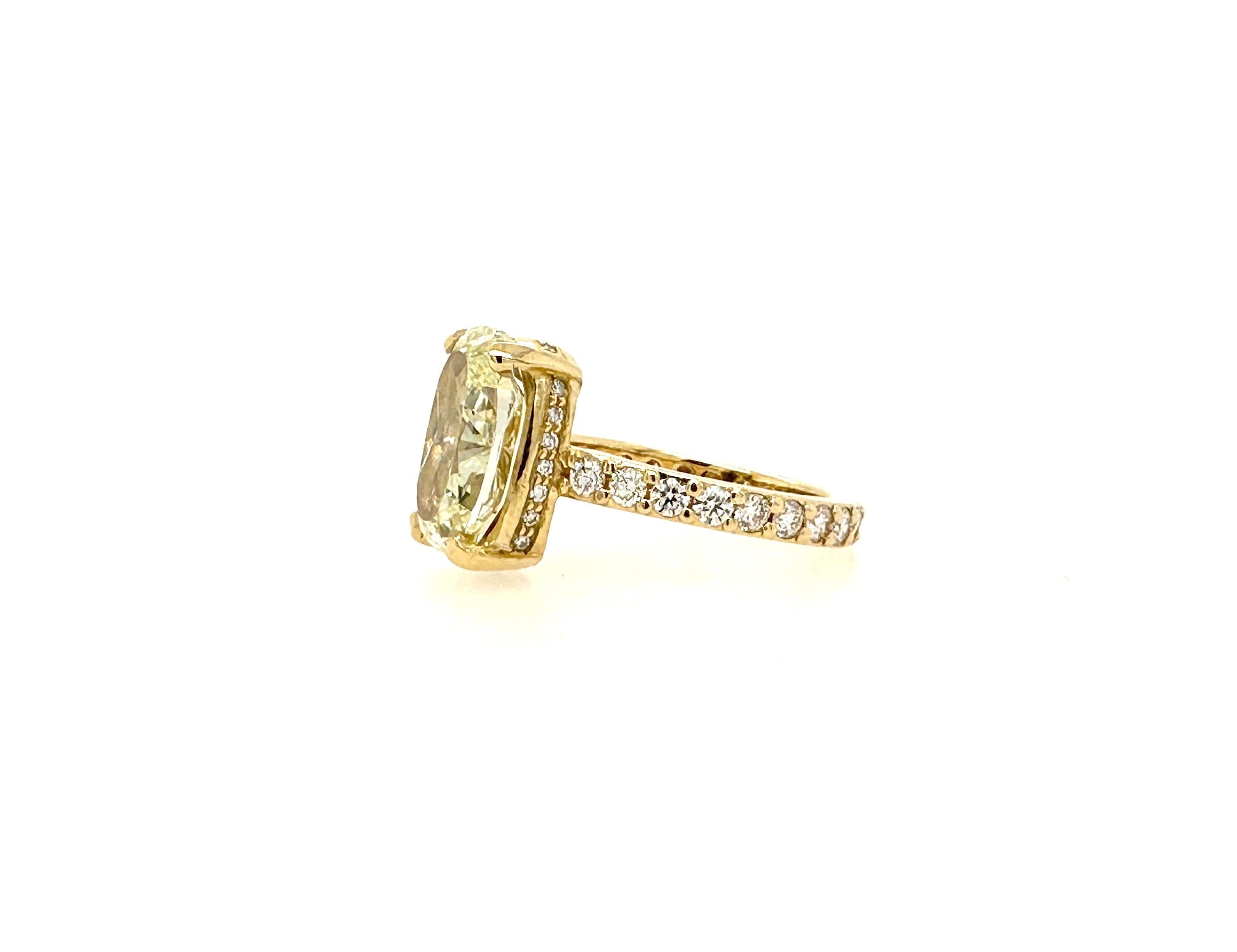 Fancy light yellow oval shape diamond weighing 4.31 carat set in 18k yellow gold hidden halo ring with approximately 1.5 carat total weight of white (F-G) VS1 diamonds.
This oval is longer and thinner than usual to give a bigger look.
Center diamond