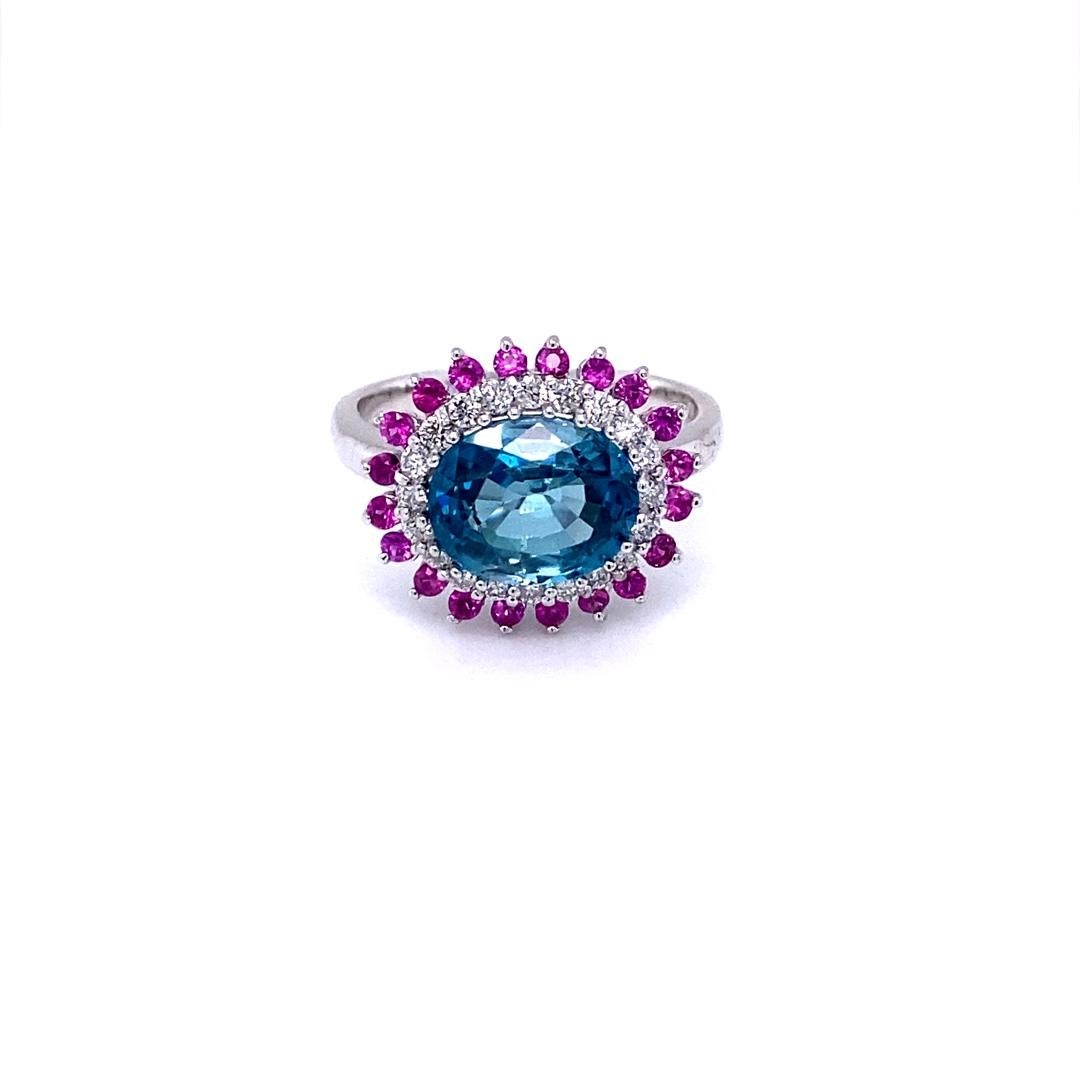 A Dazzling Blue Zircon, Pink, Yellow Sapphire and Diamond Ring! 
Blue Zircon is a natural stone mined in different parts of the world, mainly Sri Lanka, Myanmar, and Australia. 

This Blue Zircon is 3.59 Carats and is surrounded by 20 Pink Sapphires