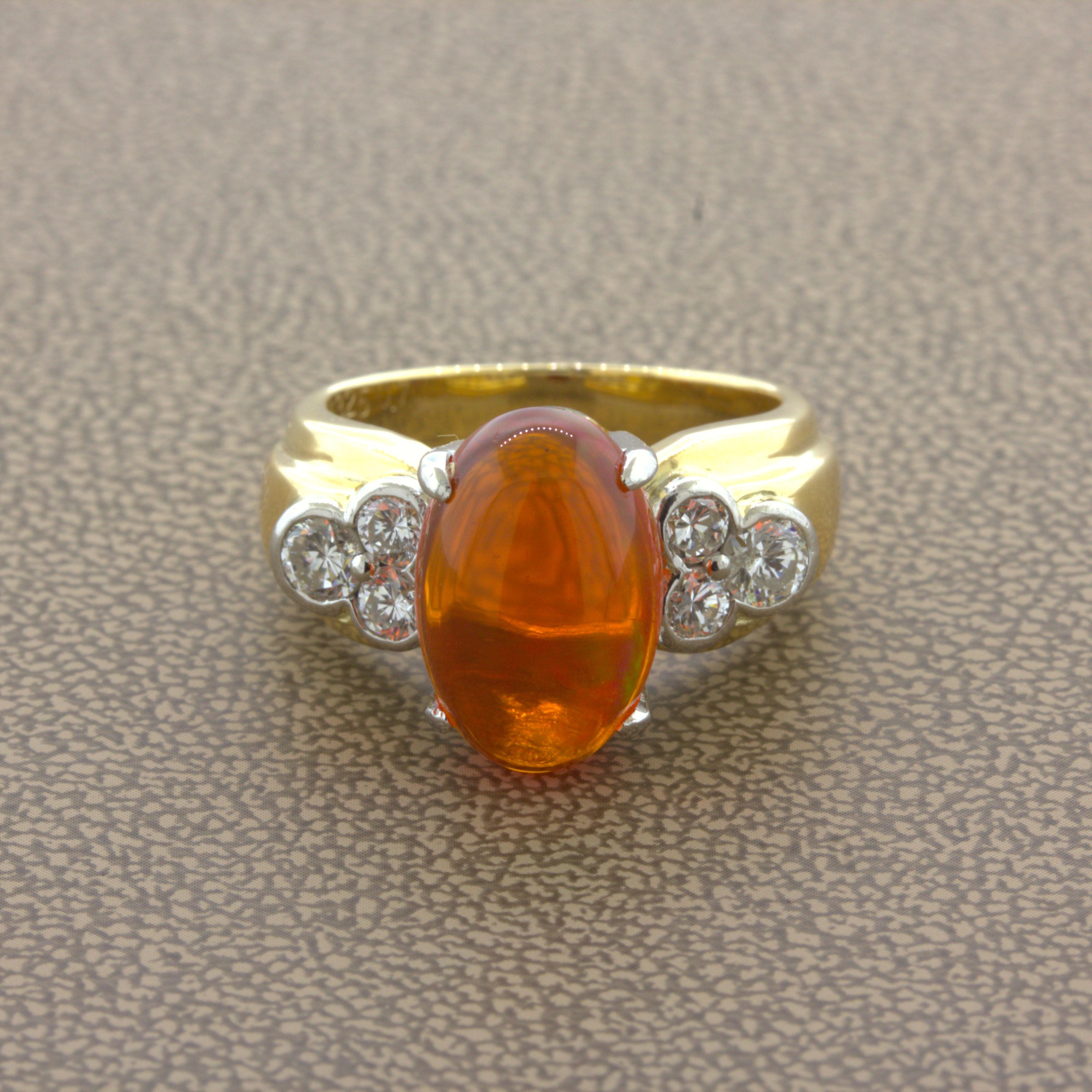A superb gem fire opal takes center stage. It weighs 4.32 carats and has a super gemmy vivid orange-red color excellent play-of-color. Flashes or orange, yellow, green, and red can all be seen as you look at the opal at different angles. It is
