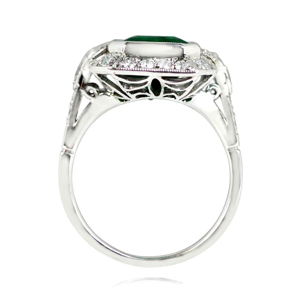 This platinum ring is adorned with a vibrant natural emerald weighing around 4.32 carats as its centerpiece. The emerald boasts vivid green color and is complemented by a row of old-cut diamonds surrounding it, as well as the shoulders. The ring