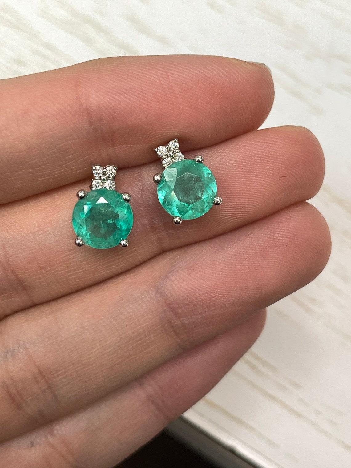Elegance defined! These beautiful Colombian emerald and diamond earrings are handmade in solid 14k white gold. These studs feature genuine large and rare Colombian emeralds accented with natural white brilliant diamonds. The emeralds have a combined