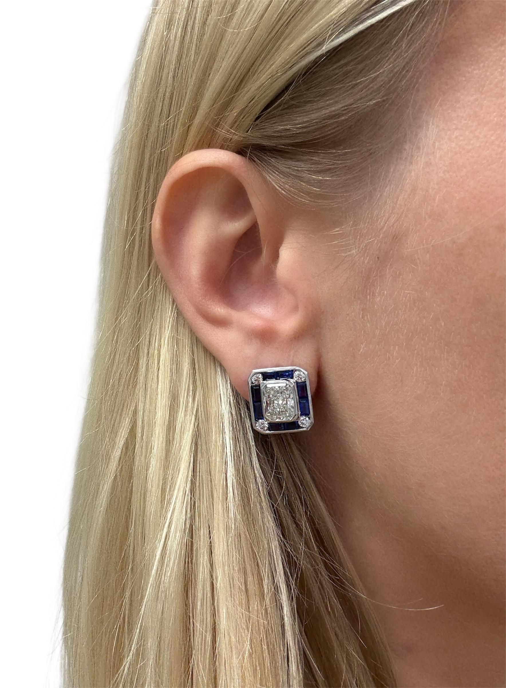 Diese wunderschönen Ohrringe enthalten zwei Diamanten im Strahlenschliff mit einem Gewicht von 2,19 und 2,15 Karat, umgeben von rechteckigen Saphiren im Stufenschliff und runden Diamanten im Brillantschliff. In Platin gefasst 

Metall: