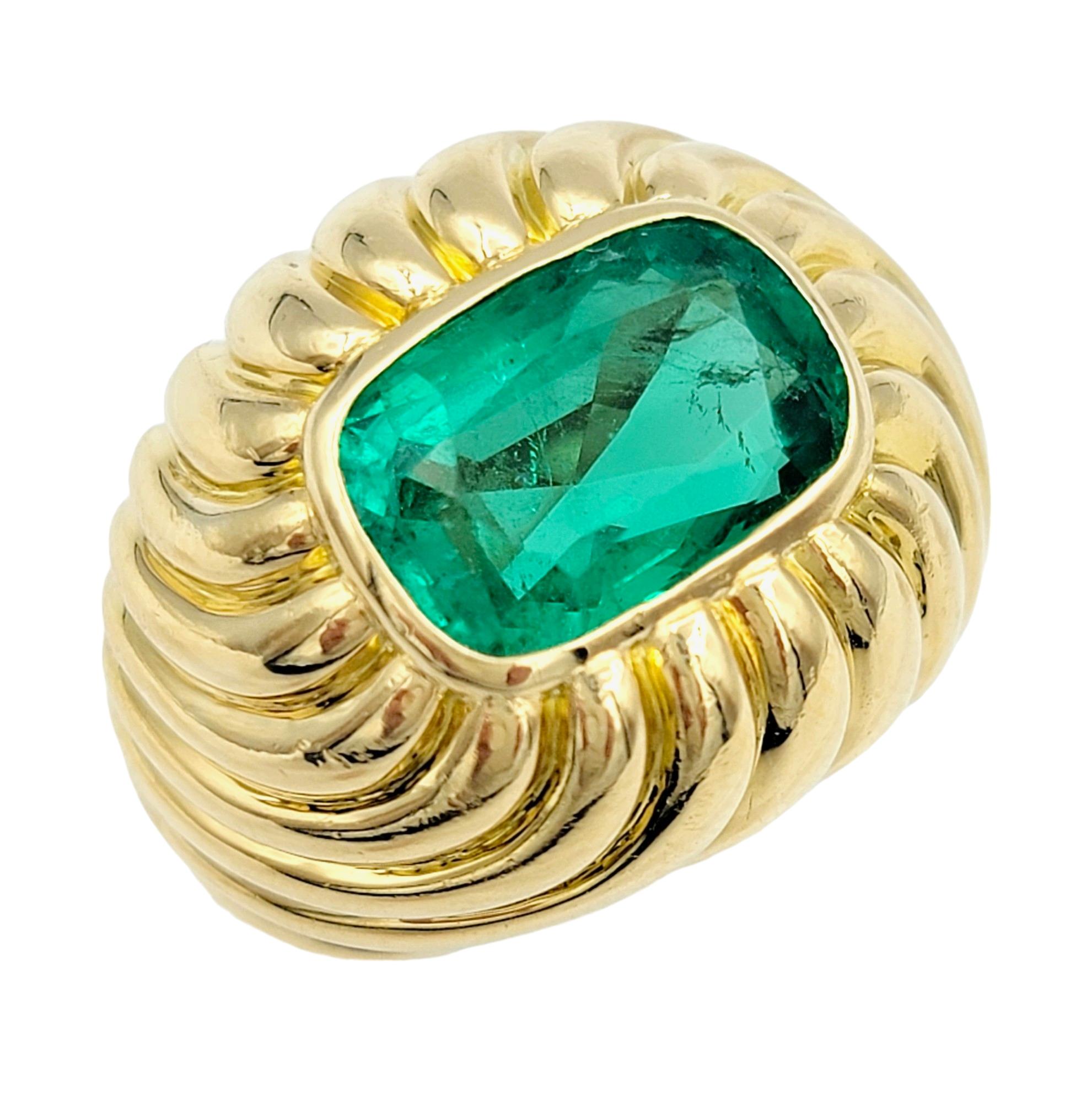 Ring Size: 6.5

This elegant emerald dome solitaire ring, set in opulent 18 karat yellow gold, is a striking piece that commands attention. The centerpiece of this ring is a cushion-cut emerald, showcasing its vibrant green hue and exceptional