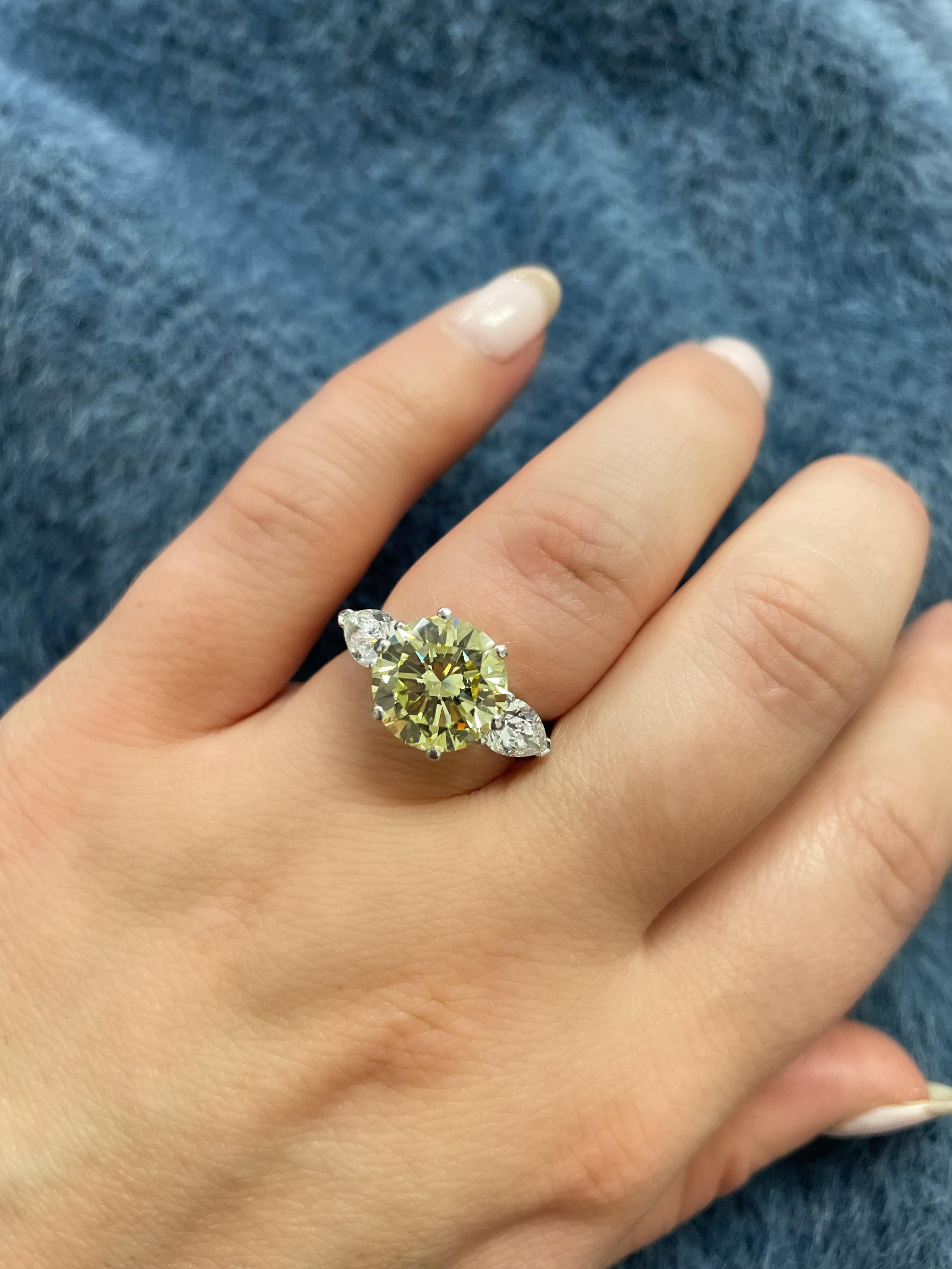 This gorgeous ring boasts a Natural Fancy Yellow round brilliant cut diamond weighing 4.35 carats, flanked by two white pear shape diamonds weighing 1.15 carats.

Ring size: 6 1/4.
Metal: Platinum.
Stamp: PLAT.
Gross weight: 8.40 grams.

GIA, 2024,