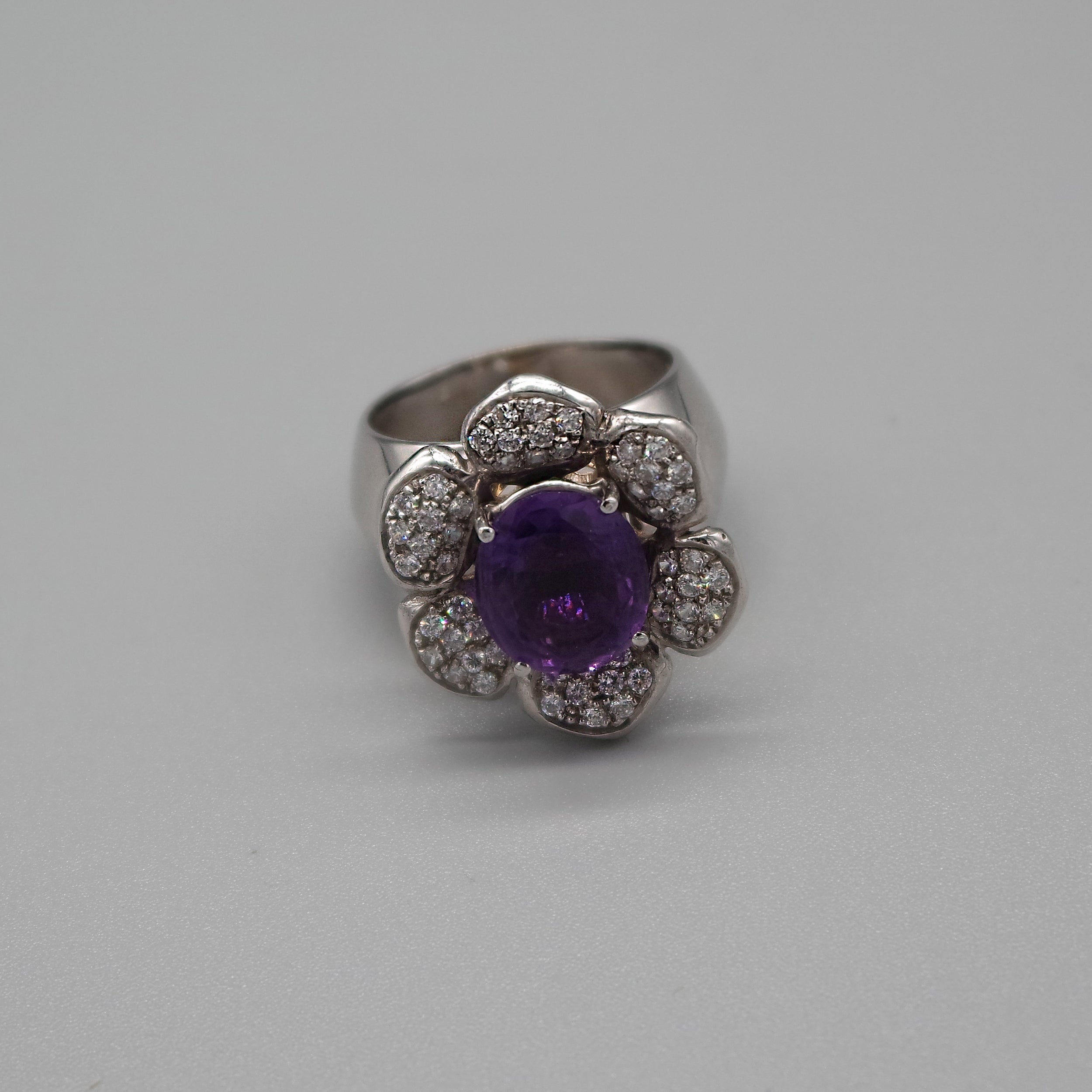 A stunning vintage 4.35 carat amethyst and 0.55 carat diamond, 18 Kt white gold cocktail ring; 

This flower-inspired central displays an oval shape amethyst at the center of the design, flanked by 54 diamonds pavé-set petals. 
The joyful part of