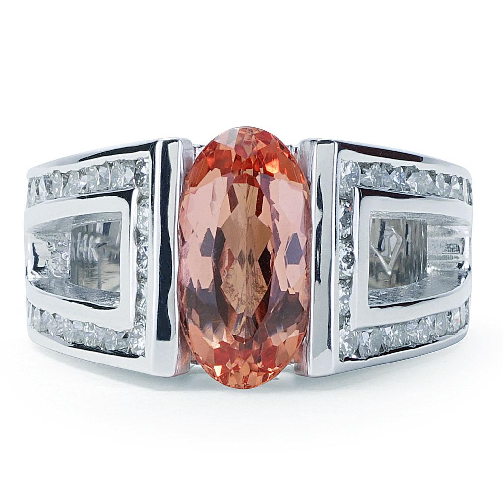 This fashion ring is made of 14K white gold and weighs approx. 14 grams. The center stone is an oval cut pinkish orange Imperial Topaz weighing 3.00 carats. It is accented by 38 round cut diamonds G-H color, VS clarity weighing a total of 1.35