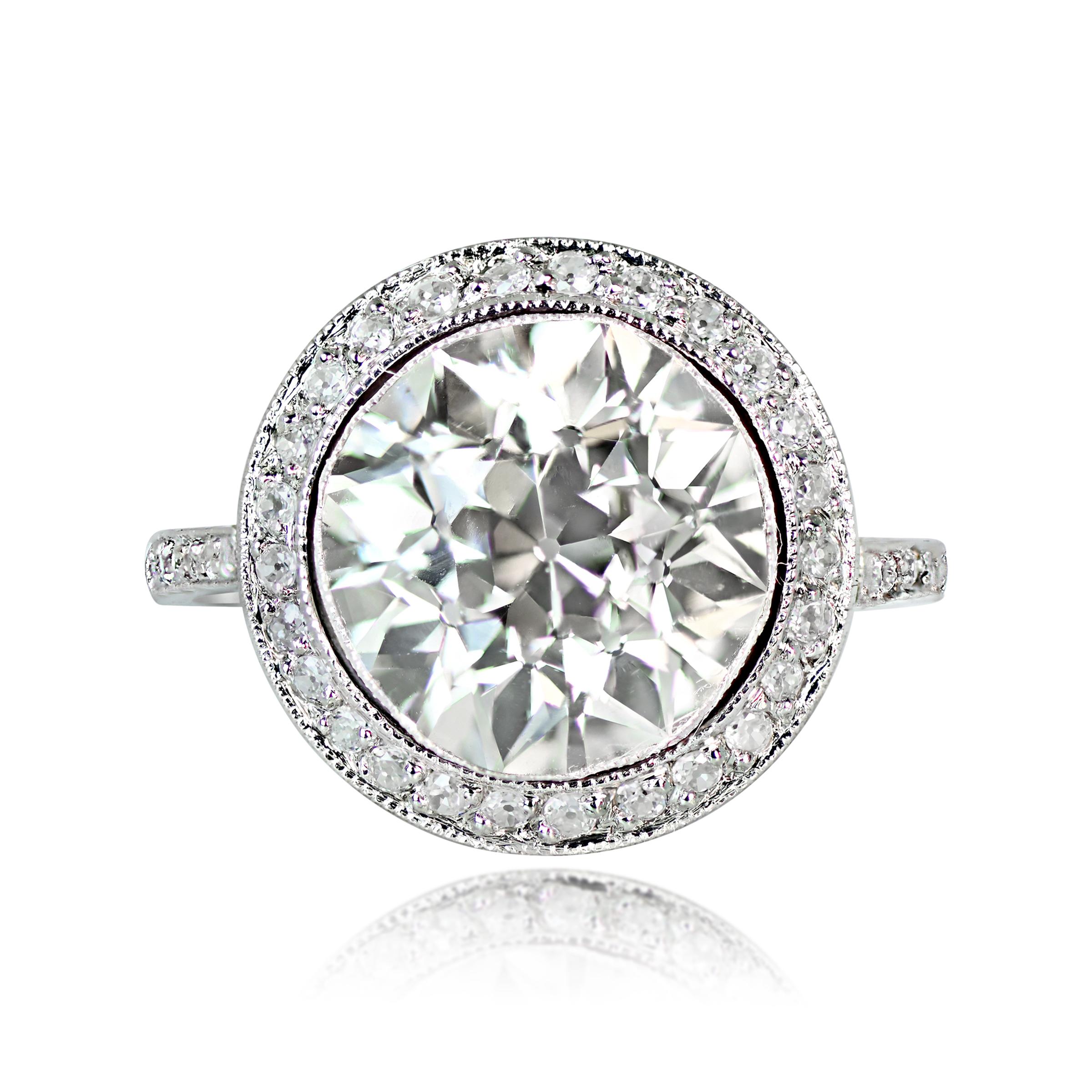 This is a stunning engagement ring features a remarkable 4.37 carat old European cut diamond with a lively sparkle, showcased in a sleek bezel setting. The diamond's L color and VS2 clarity are complemented by a stunning halo of pave-set old