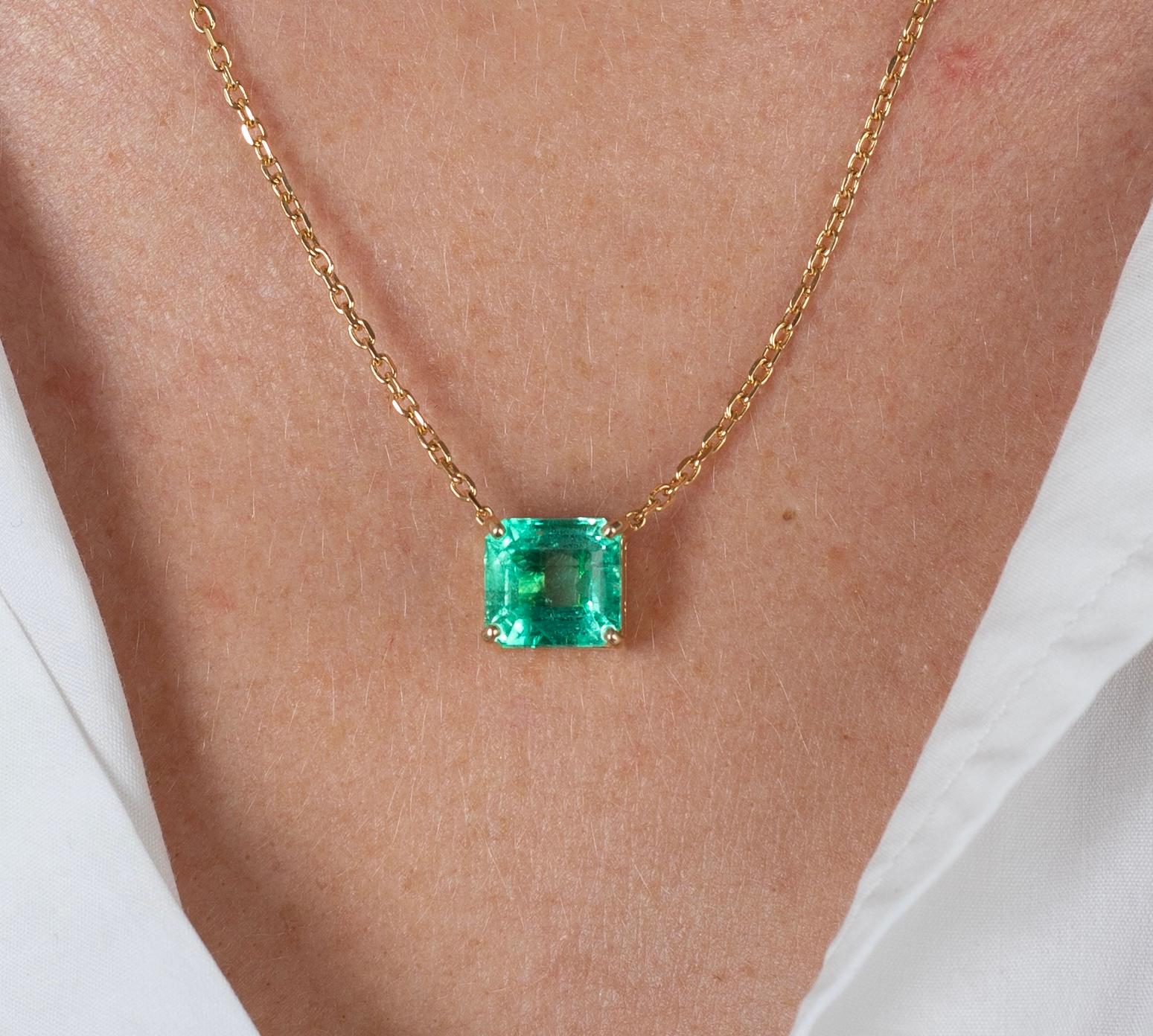 Vivid green emerald cut Colombian Emerald with minor oil treatment. The center stone features excellent luster, transparency, and brilliance. Set in an 18k solid gold floating-style cable chain necklace. The setting back provides excellent contrast