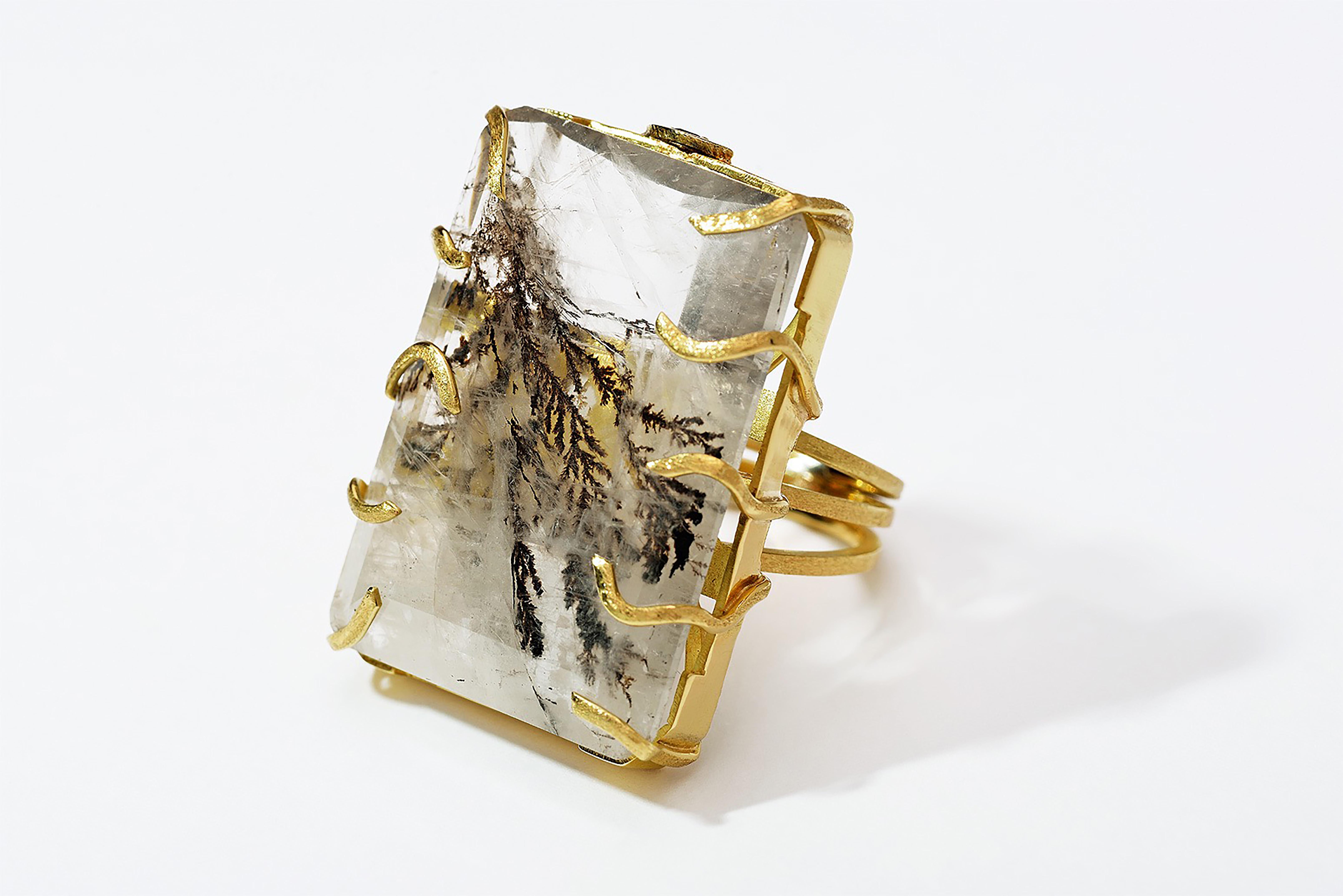 Dendrite, (from the Greek word: Tree) quartz is part of the quartz inclusion family. This beautiful variety of quartz contains fern-like inclusions of iron, manganese, hematite, and other metals.
Handcrafted in 18k yellow gold, the Auna ring is part