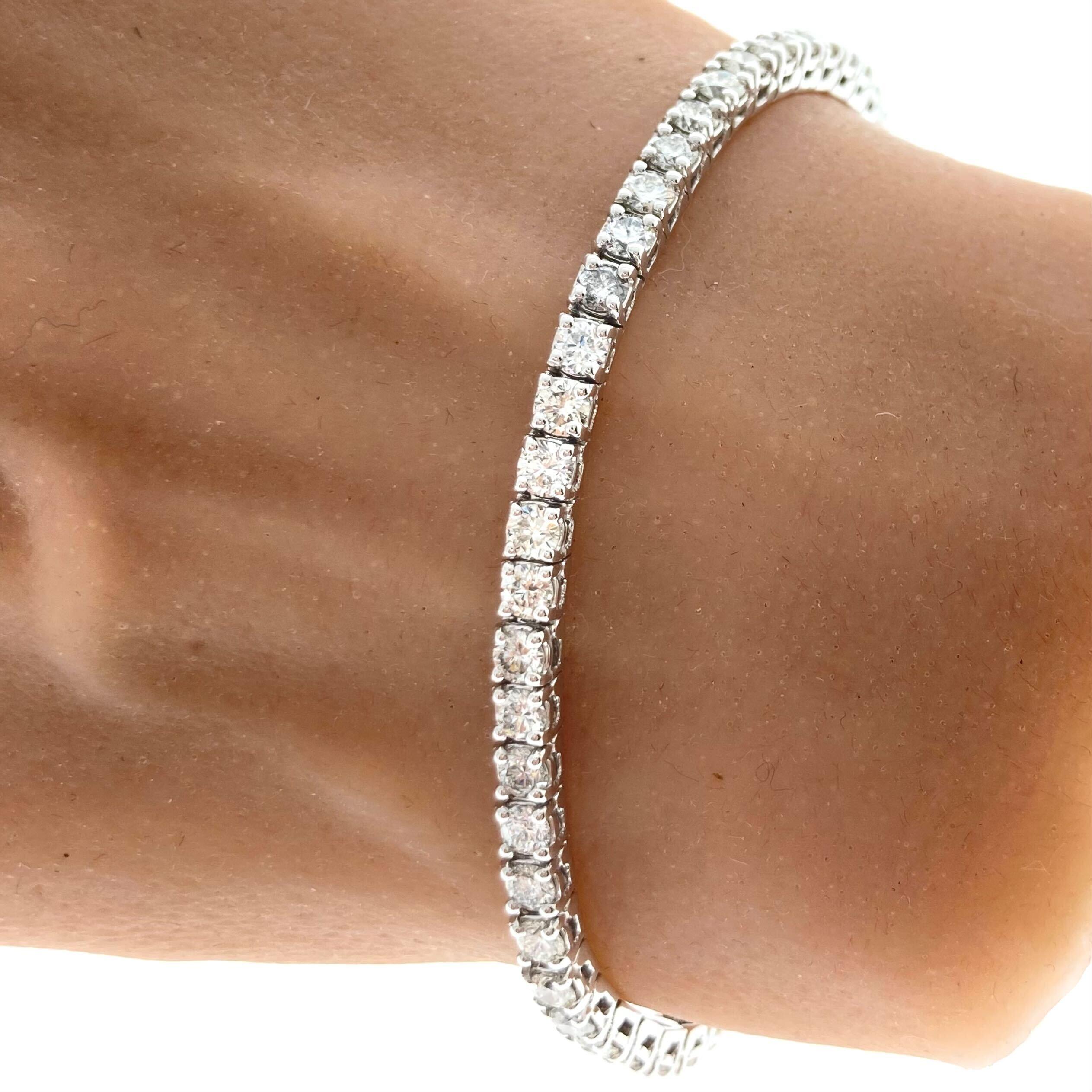 A 4-prong diamond bracelet featuring round-cut diamonds as the main stones with a total carat weight of 4.38 carats. The color of the diamonds is in the G-H range, indicating near-colorless to faint color. The clarity is graded as SI1-SI2, meaning