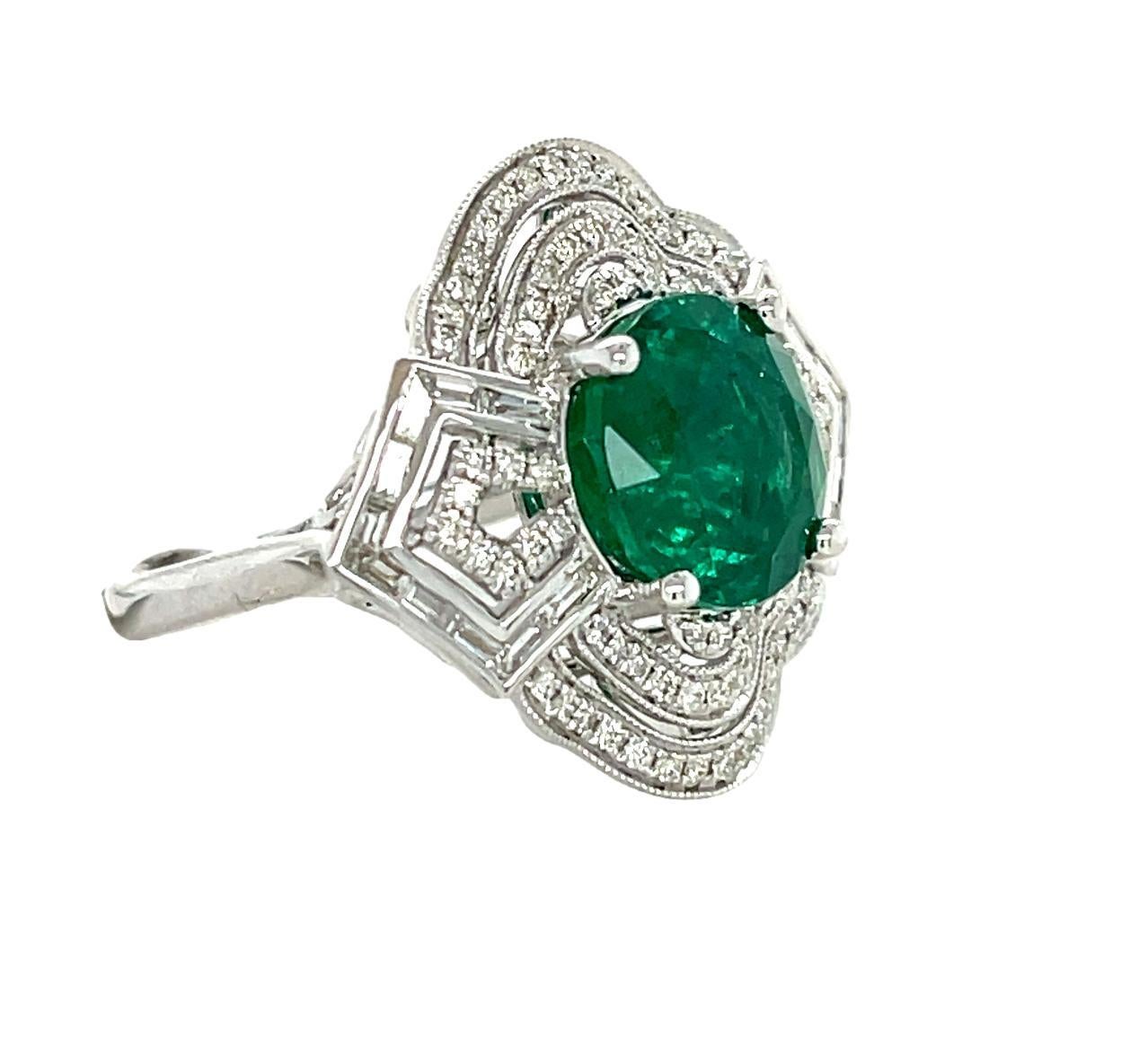 This beautiful Statement ring has a 10 mm round Zambian Emerald with 4 prong setting in 14 karat white gold. There are top quality sparkling baguette and brilliant cut round diamonds surrounding the center piece for added elegance. This beautiful