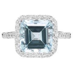 Bague en or blanc 18 carats avec une aigue-marine carrée de 4,39 carats entourée d'un halo de diamants