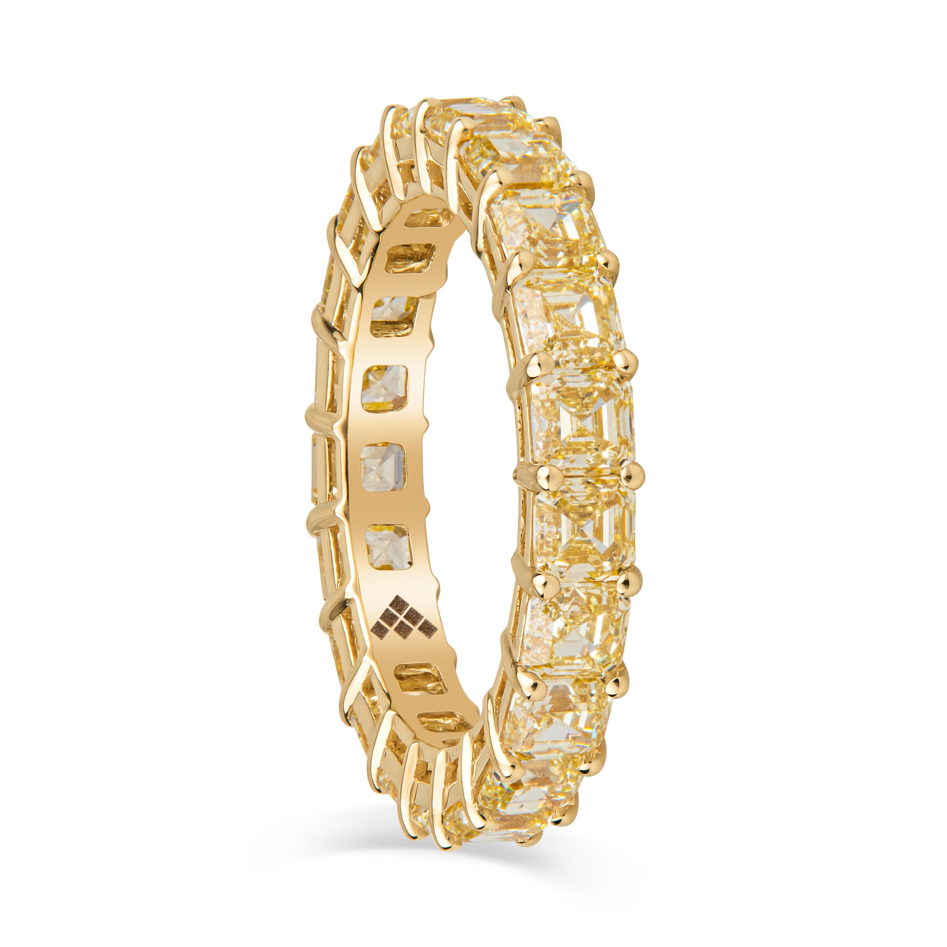 This stunning eternity band features 4.39ct total weight in 21 Asscher cut Fancy Yellow diamonds, set in an 18kt yellow gold, low profile, open basket style band in a size 6. Contact us for resizing options. The diamonds are of fancy yellow color,