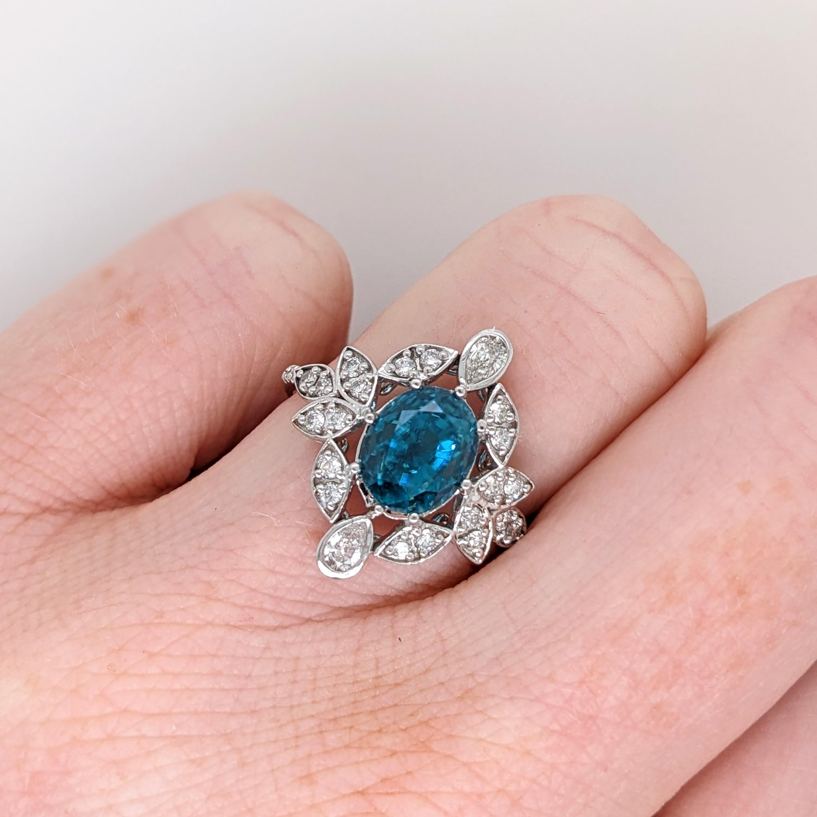 This embellished ring features a stunning vibrant 4.3ct oval blue zircon in a 14K white gold setting. This ring makes for a stunning accessory to any look! A fancy ring design perfect for an eye catching engagement or anniversary. This ring also