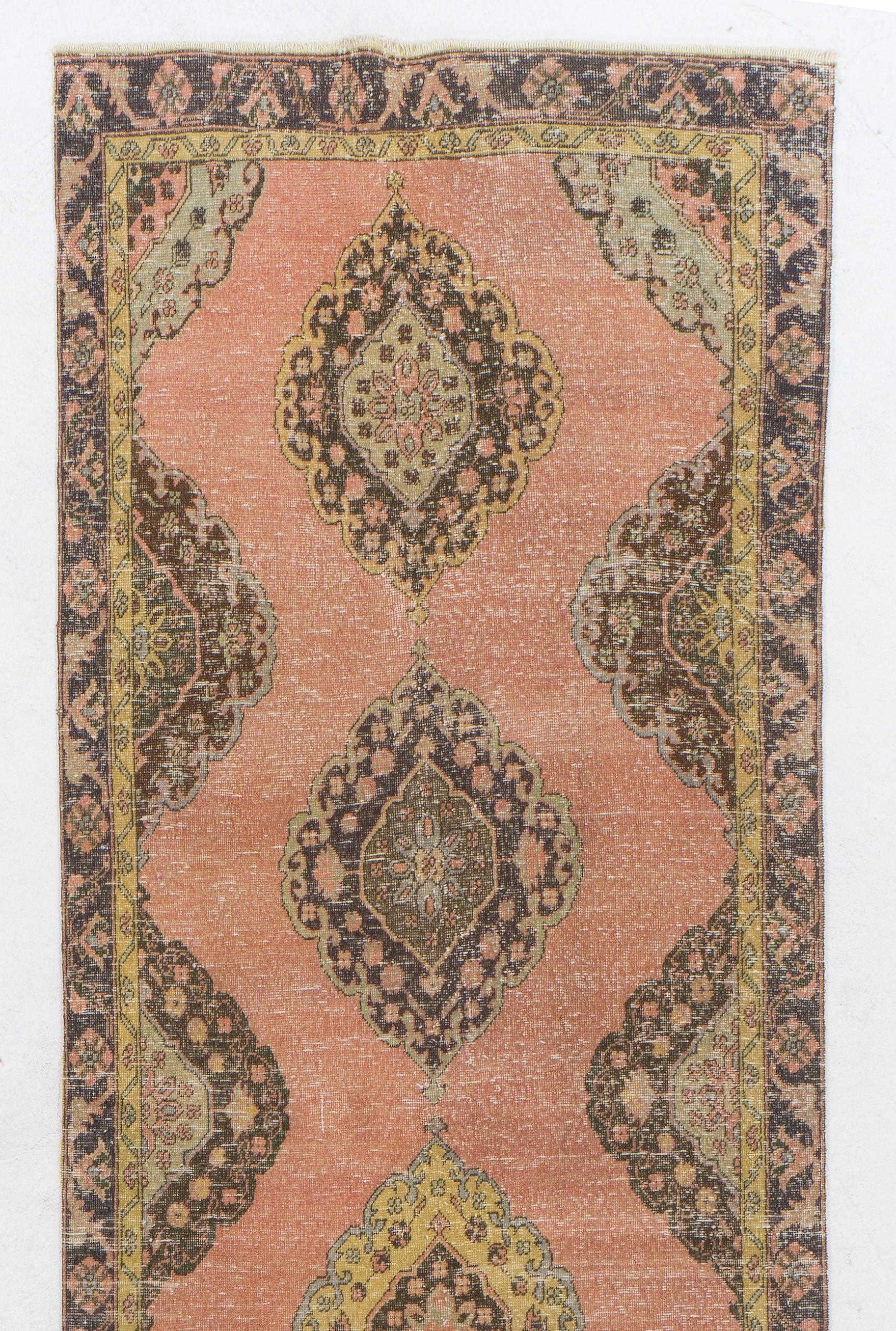 Un tapis de course vintage de Turquie. Il est composé de poils de laine de taille moyenne sur une base de laine et présente un motif à médaillons multiples. Il a été lavé de manière professionnelle, le tapis est robuste et peut être utilisé dans des
