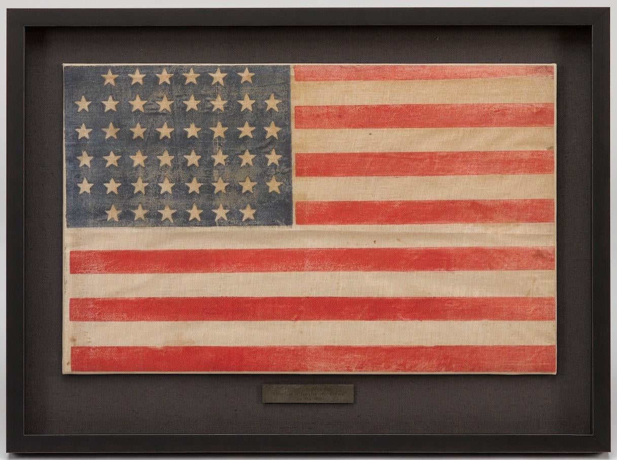This is an original antique 44-star American flag, celebrating the addition of Wyoming to the Union. The flag has a “drum” star configuration, with the 44 stars arranged in 6 rows of 6-8-8-8-8-6 stars. The stars are uniformly placed on the canton.