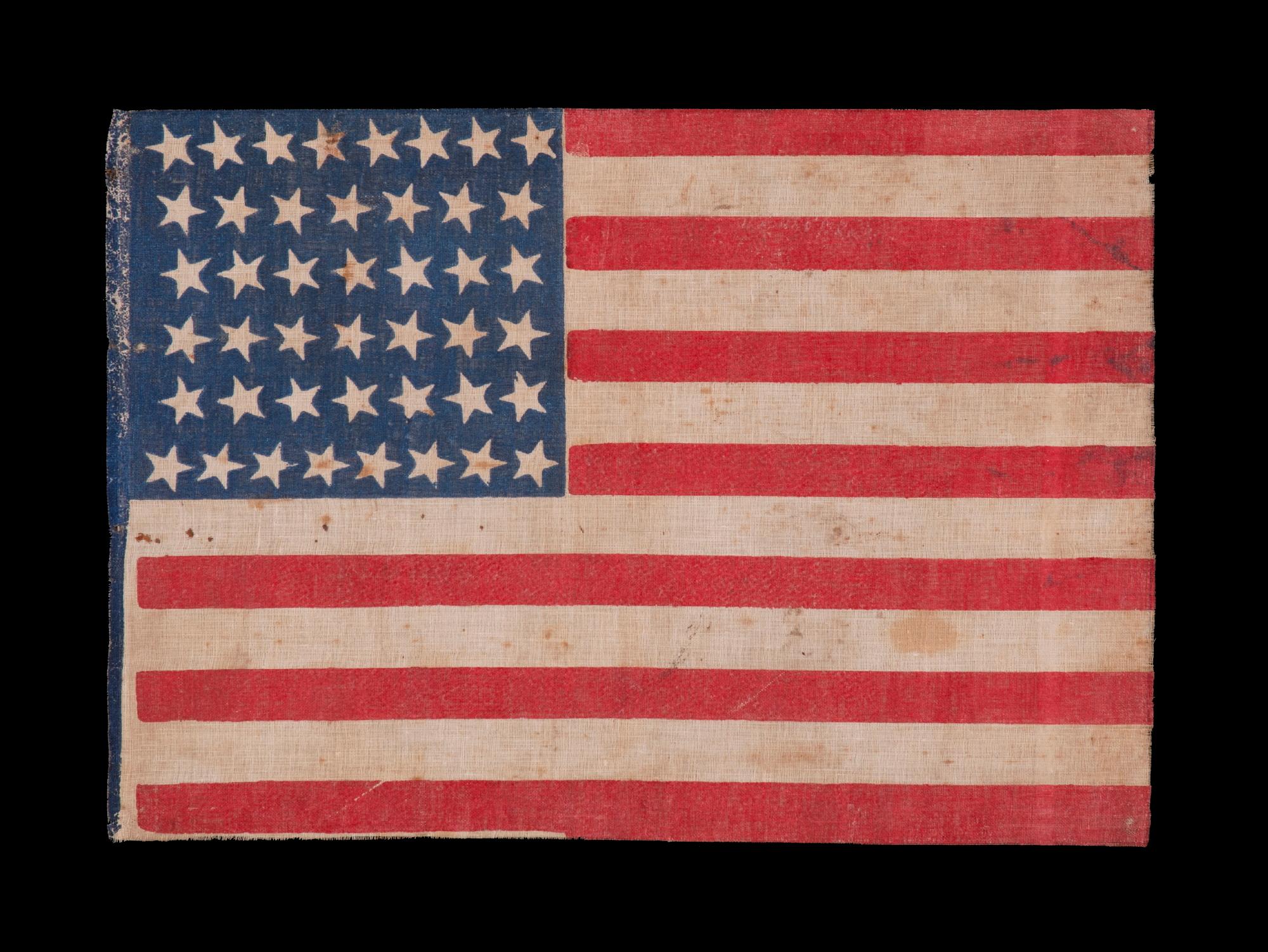 44 STAR ANTIQUE AMERICAN FLAG WITH AN HOURGLASS FORMATION ON A BRILLIANT BLUE CANTON; REFLECTS THE ERA WHEN WYOMING WAS THE MOST RECENT STATE TO JOIN THE UNION, 1890-1896

44 star American national parade flag, block-printed on coarse cotton. The
